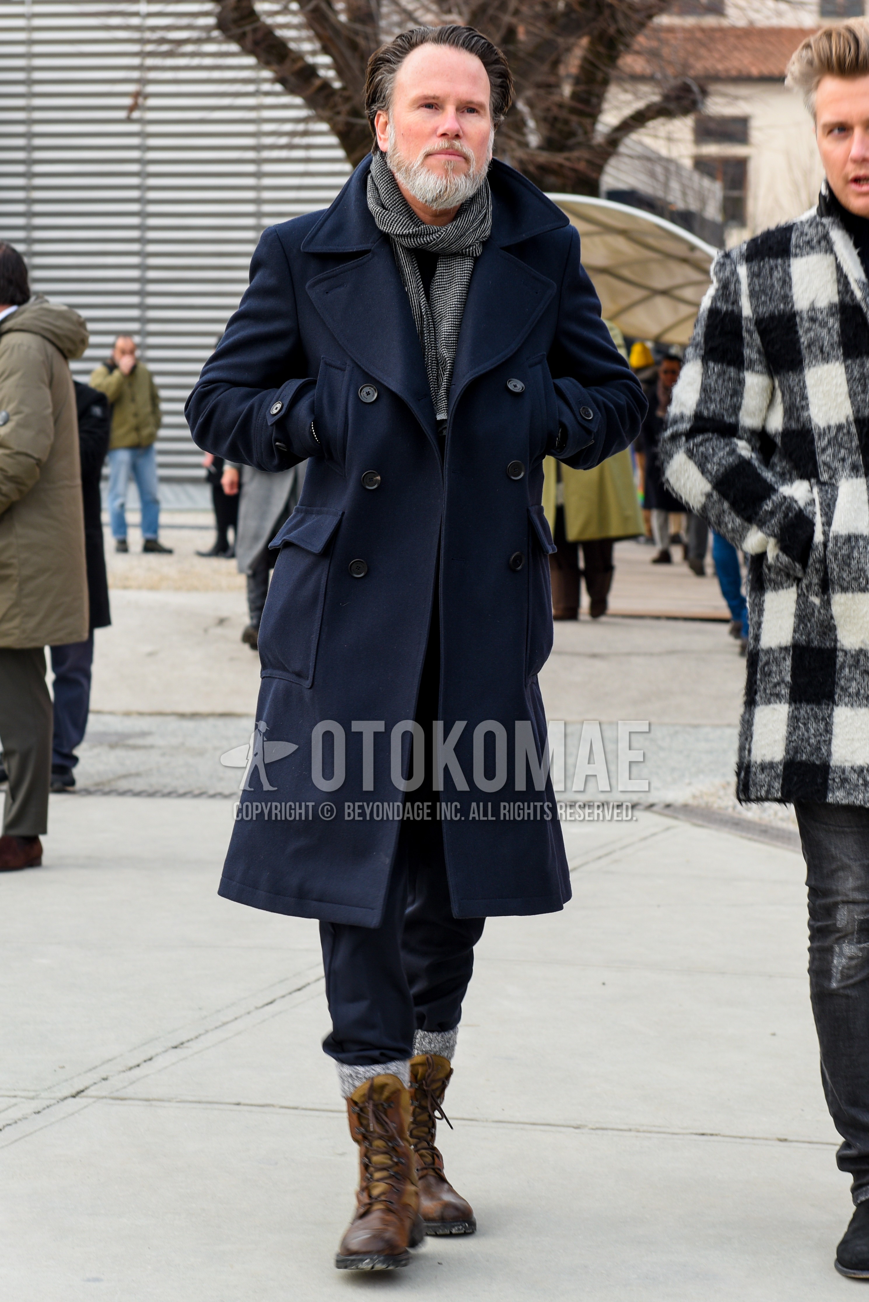 Men's autumn winter outfit with gray check scarf, navy plain ulster coat, black plain cotton pants, gray plain socks, brown  boots.