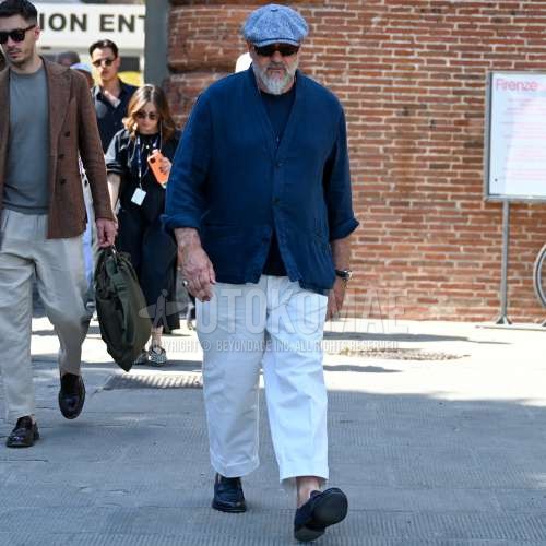 グレー無地のキャップ、ブラウン無地のサングラス、ネイビー無地のカーディガン、黒無地のTシャツ、白無地のワイドパンツ、黒コインローファーの革靴を合わせた春のメンズコーデ・着こなし。