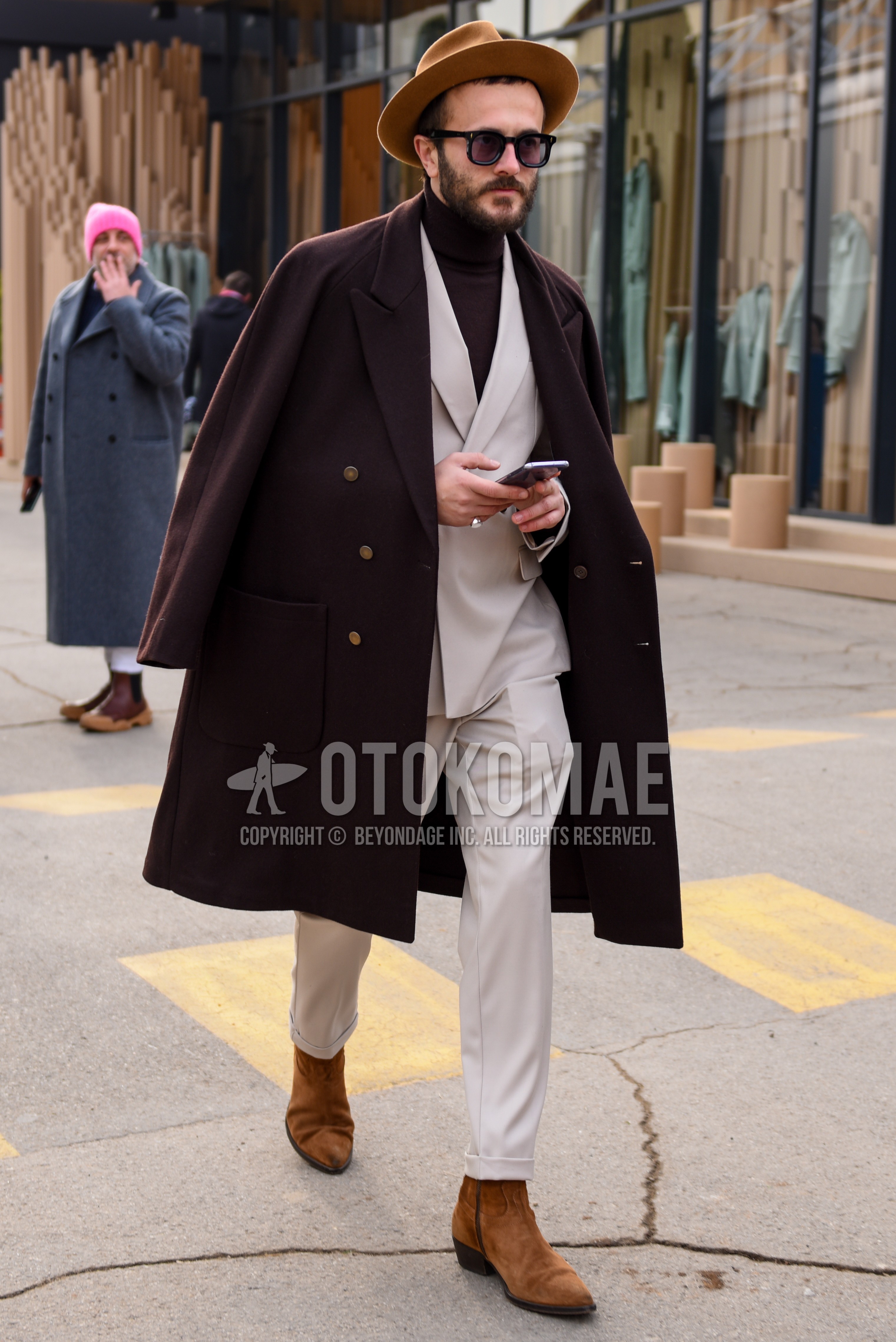 Men's autumn winter outfit with brown plain hat, black plain sunglasses, brown plain chester coat, brown plain turtleneck knit, brown side-gore boots, beige plain suit.