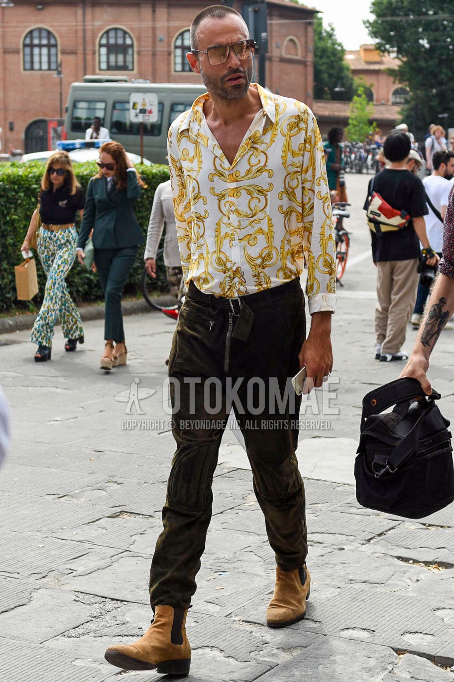 Men's spring summer outfit with black gold plain sunglasses, white tops/innerwear shirt, olive green plain bottoms, beige side-gore boots.