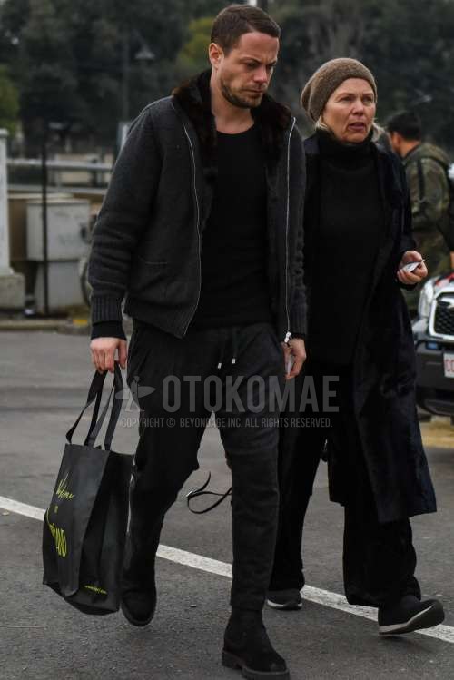 ダークグレー無地のアウター、黒無地のセーター、ダークグレー無地のイージーパンツ、黒サイドゴアのブーツを合わせた冬のメンズコーデ・着こなし。