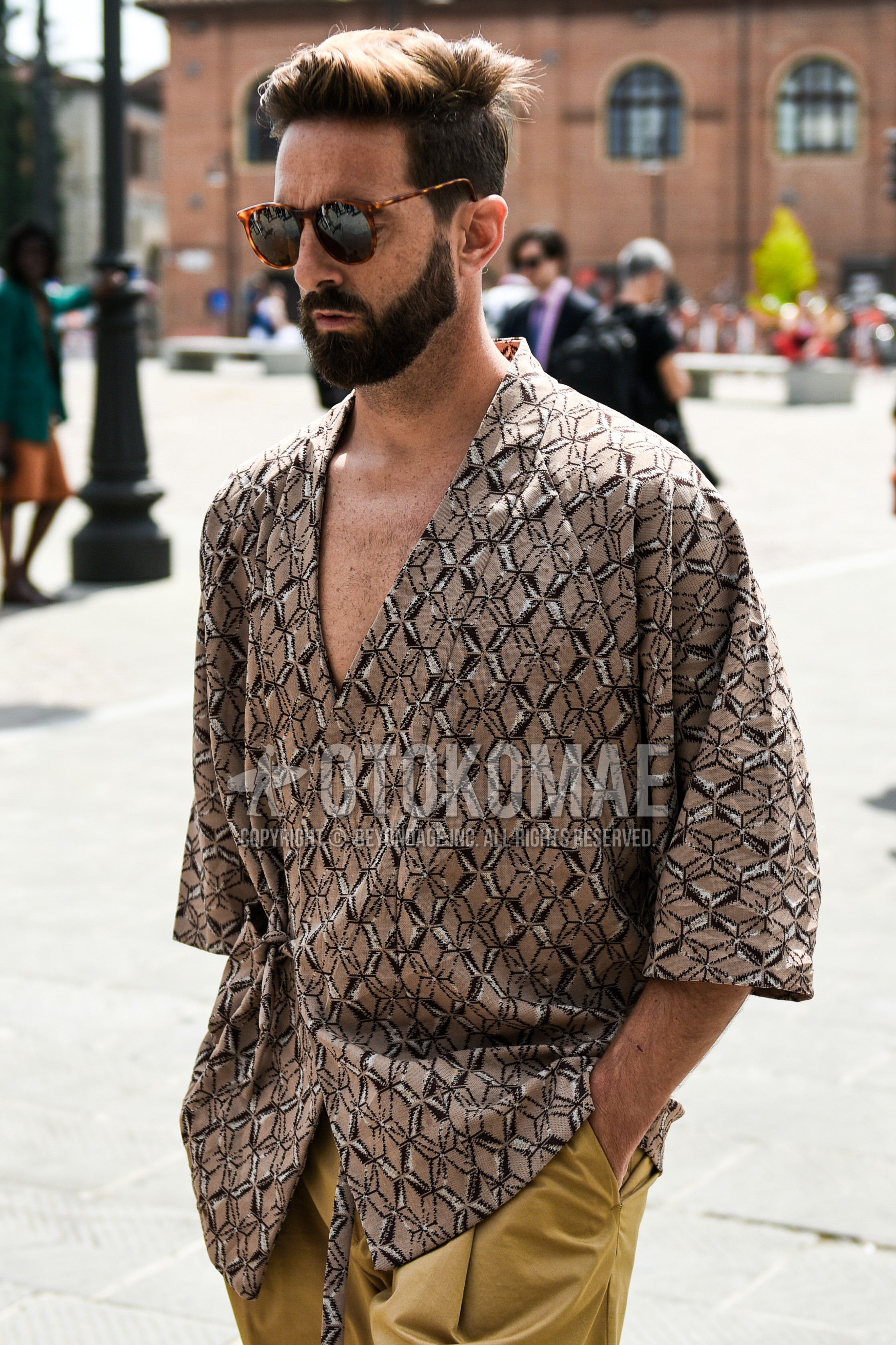 Men's summer outfit with brown tortoiseshell sunglasses, beige tops/innerwear shirt, beige plain chinos.