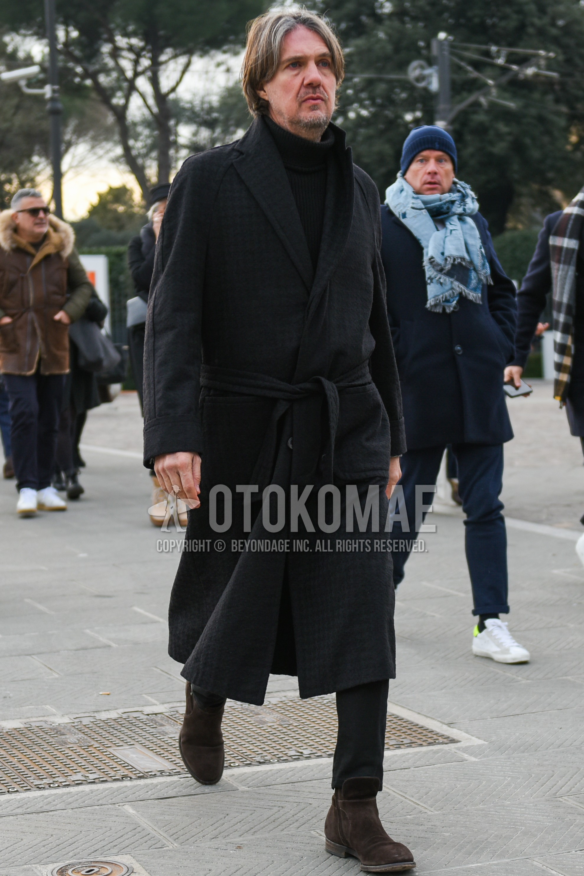 Men's autumn winter outfit with dark gray check belted coat, black plain turtleneck knit, gray plain slacks, brown side-gore boots.