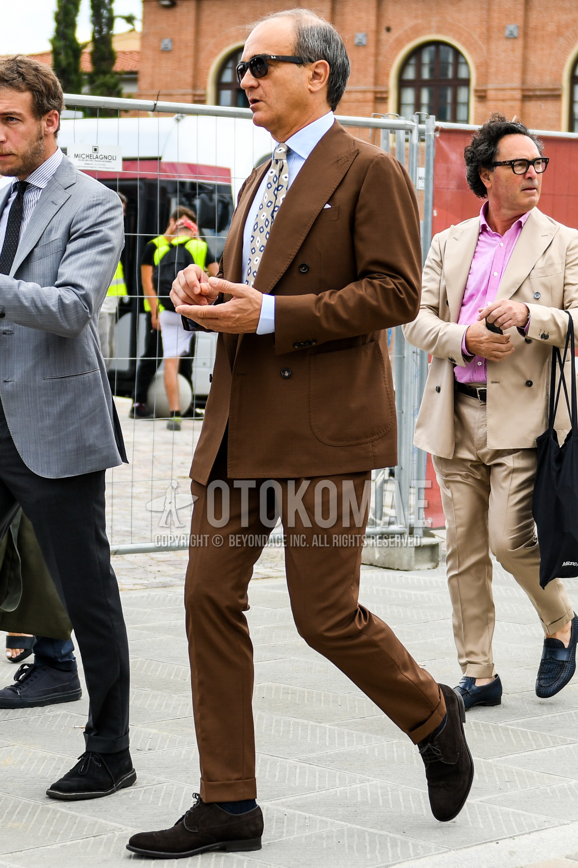 Men's spring summer autumn outfit with plain sunglasses, light blue plain shirt, brown wing-tip shoes leather shoes, brown plain suit, beige leopard necktie.