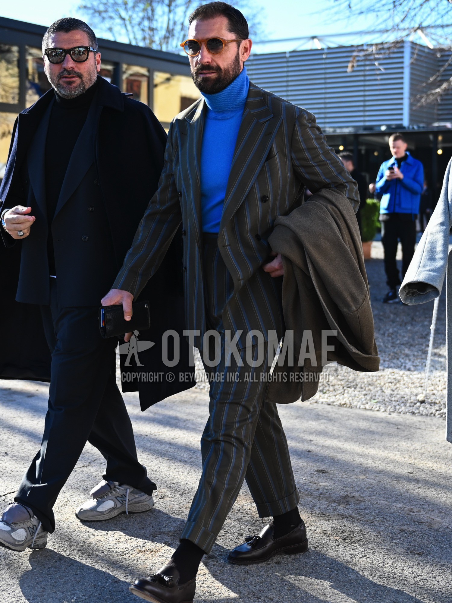 Men's autumn winter outfit with brown plain sunglasses, blue plain turtleneck knit, black plain socks, brown tassel loafers leather shoes, olive green stripes suit.