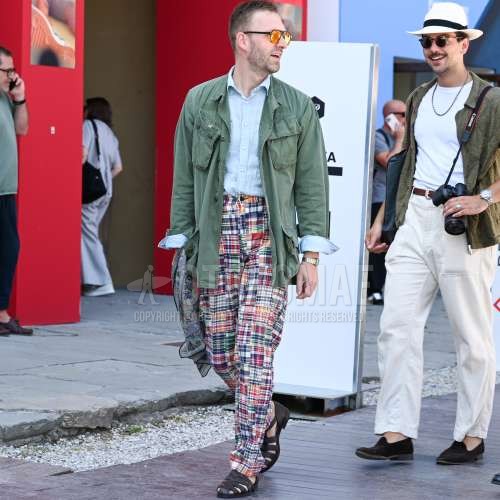 黒無地のサングラス、マルチカラーストールのスカーフ、グリーン無地のサファリジャケット、ブルー無地のデニム/シャンブレーシャツ、マルチカラーボトムスのスラックス、ブラウングルカサンダルを合わせた夏春のメンズコーデ・着こなし。