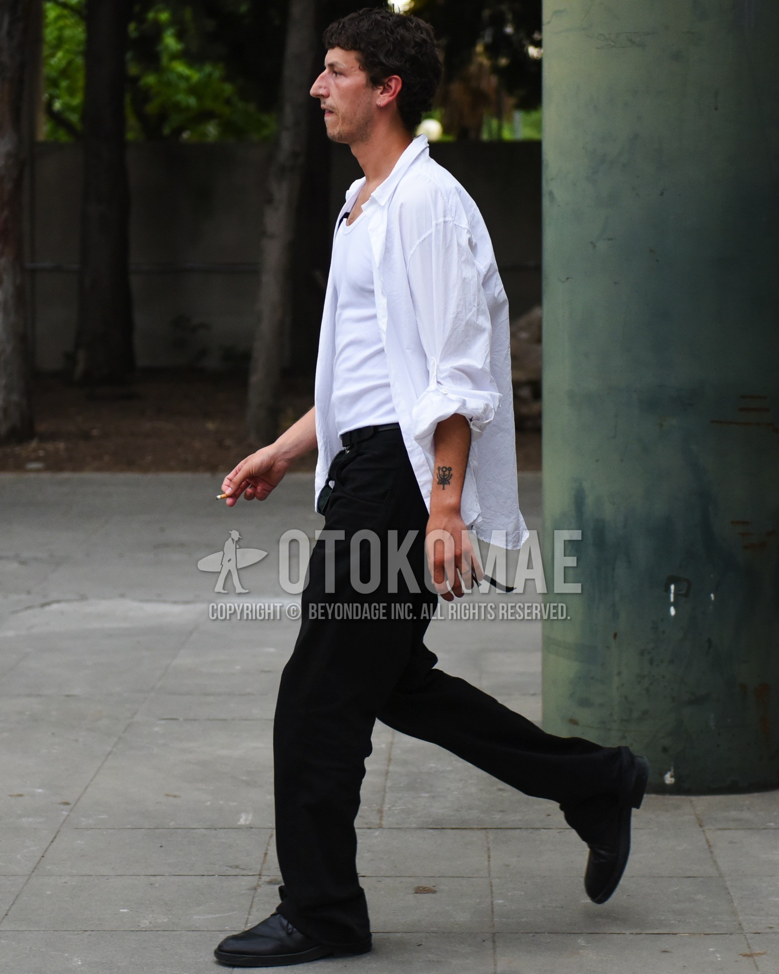 Men's spring summer outfit with white plain shirt, white plain t-shirt, black plain leather belt, black plain chinos, black plain toe leather shoes.