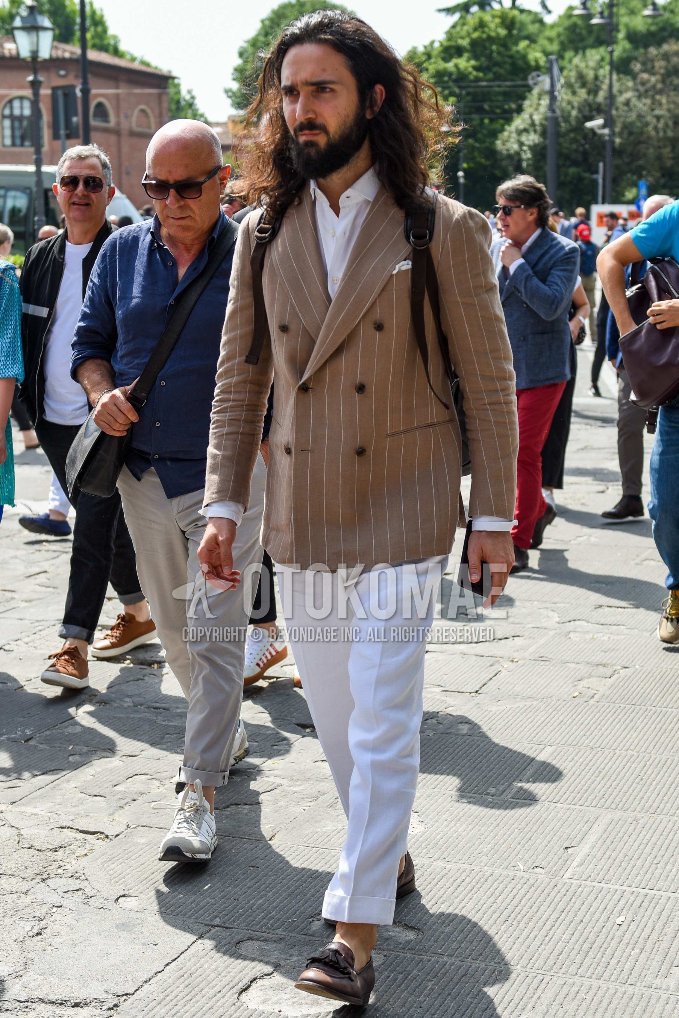 Men's spring summer autumn outfit with beige stripes tailored jacket, white plain shirt, white plain slacks, brown tassel loafers leather shoes.