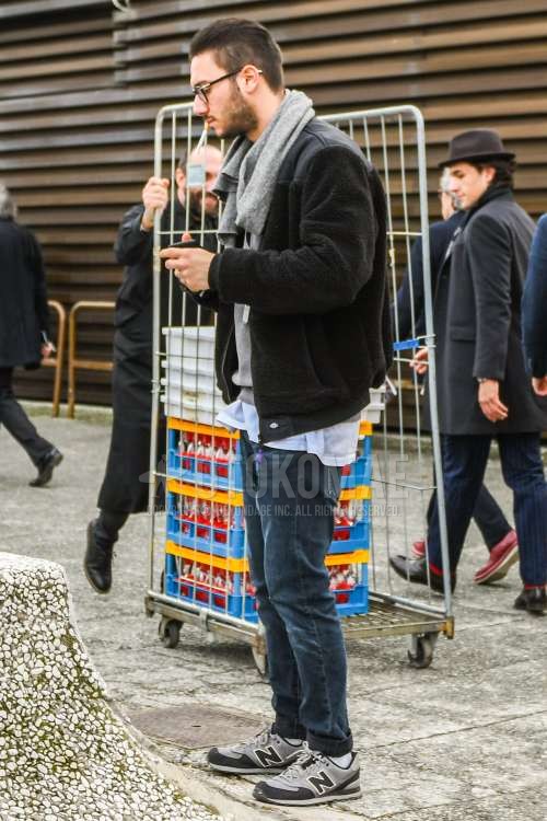 黒無地のメガネ、グレー無地のマフラー/ストール、黒無地のフリースジャケット、白無地のTシャツ、グレー無地のトレーナー、グレー無地のデニム/ジーンズ、白無地のソックス、ニューバランスのグレーローカットのスニーカーを合わせた秋冬のメンズコーデ・着こなし。