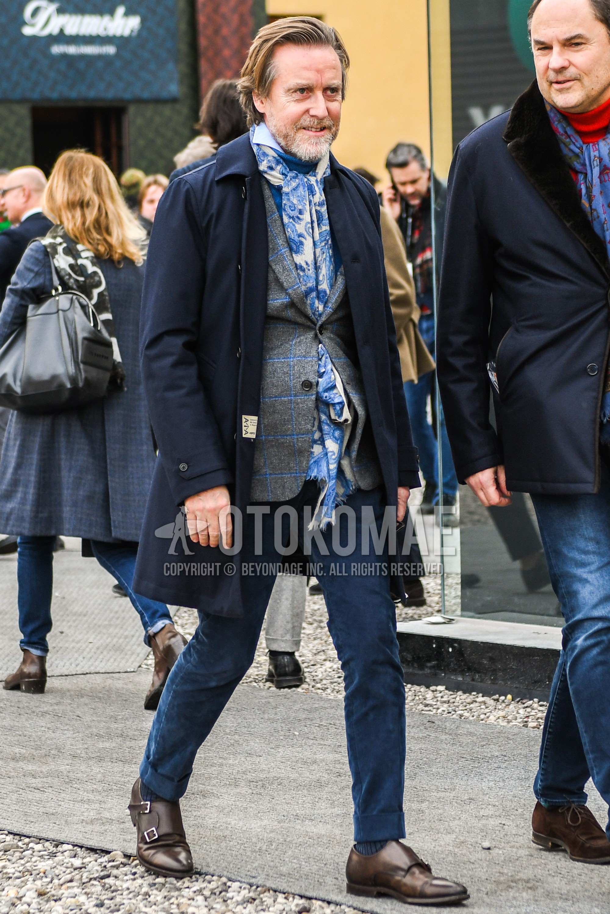 Men's winter outfit with white blue scarf scarf, navy plain stenkarrer coat, blue plain turtleneck knit, gray check tailored jacket, navy plain chinos, gray stripes socks, brown monk shoes leather shoes.
