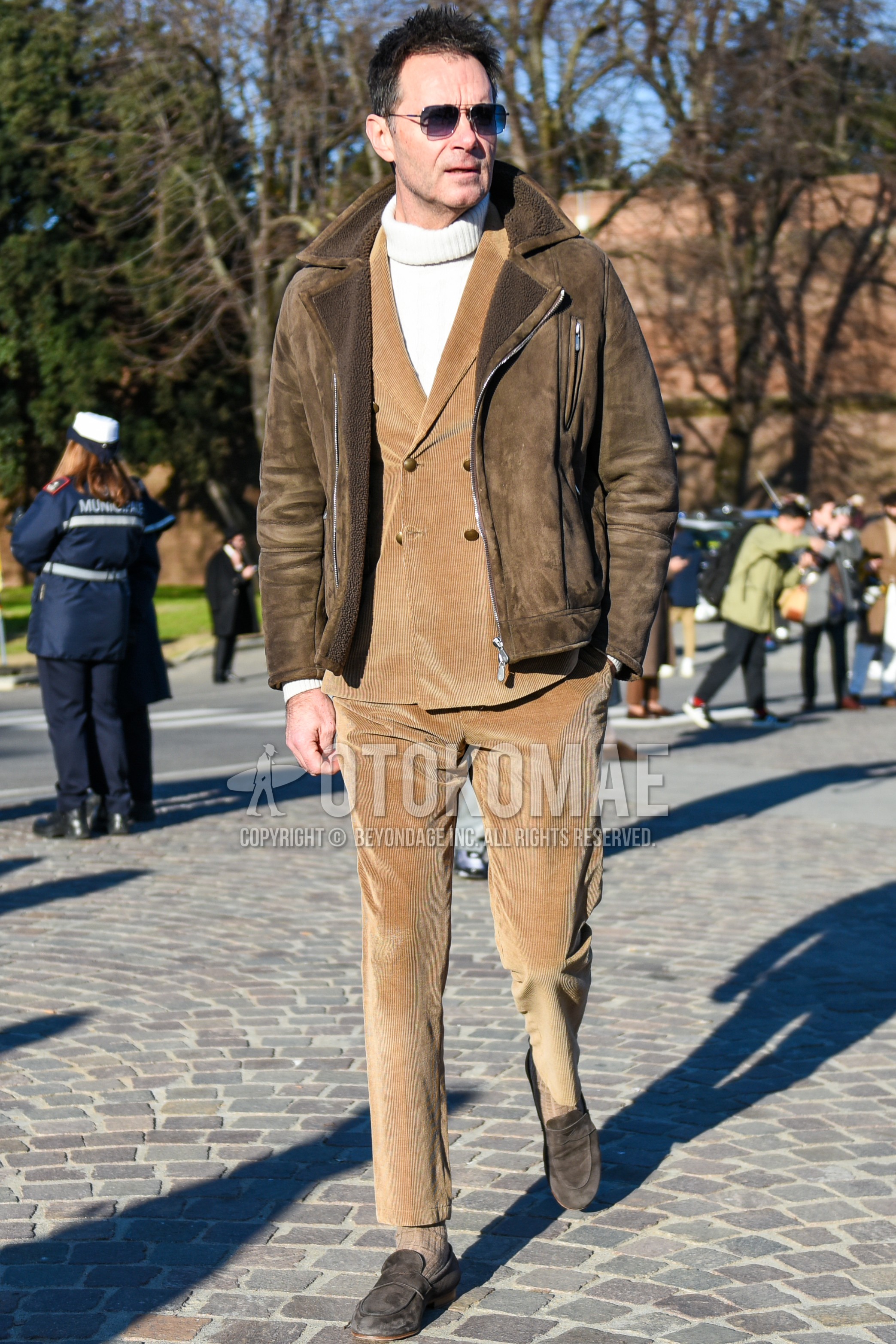 Men's autumn winter outfit with silver plain sunglasses, brown plain riders jacket, white plain turtleneck knit, beige plain socks, brown coin loafers leather shoes, beige plain suit.