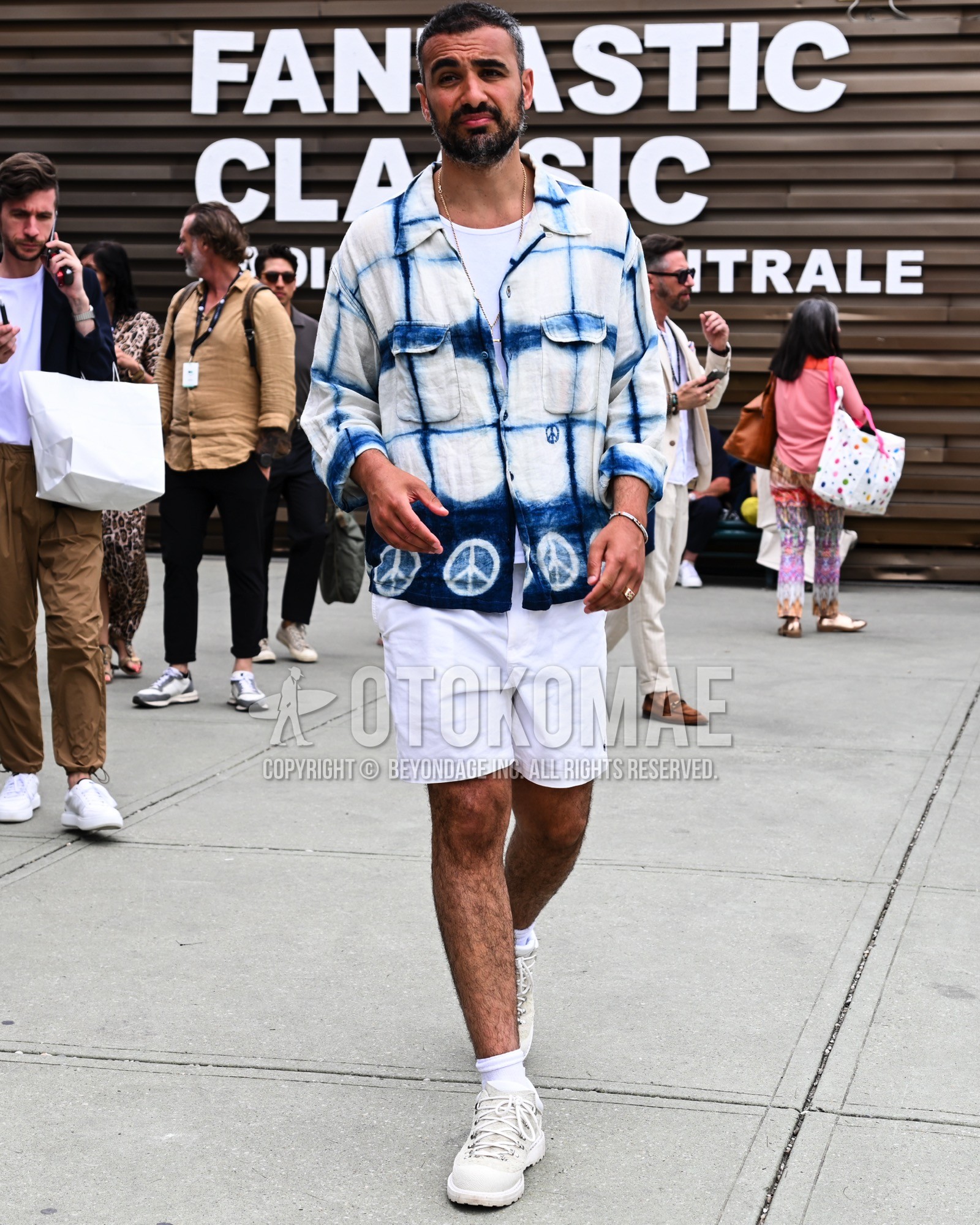 Men's spring summer outfit with white check shirt jacket, white plain short pants, white plain socks, white low-cut sneakers.