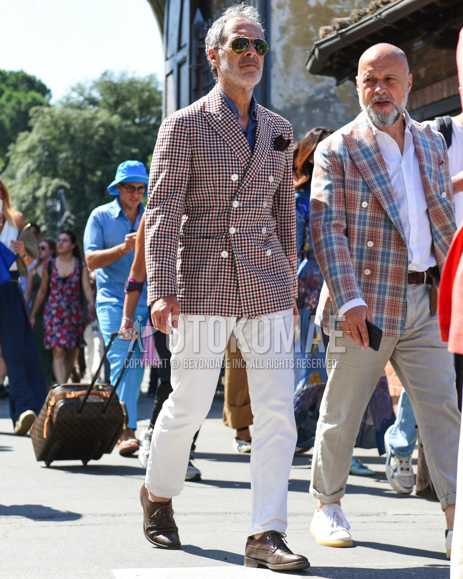 Men's spring summer outfit with gold plain sunglasses, red green white check tailored jacket, blue plain shirt, white plain cotton pants, brown brogue shoes leather shoes.