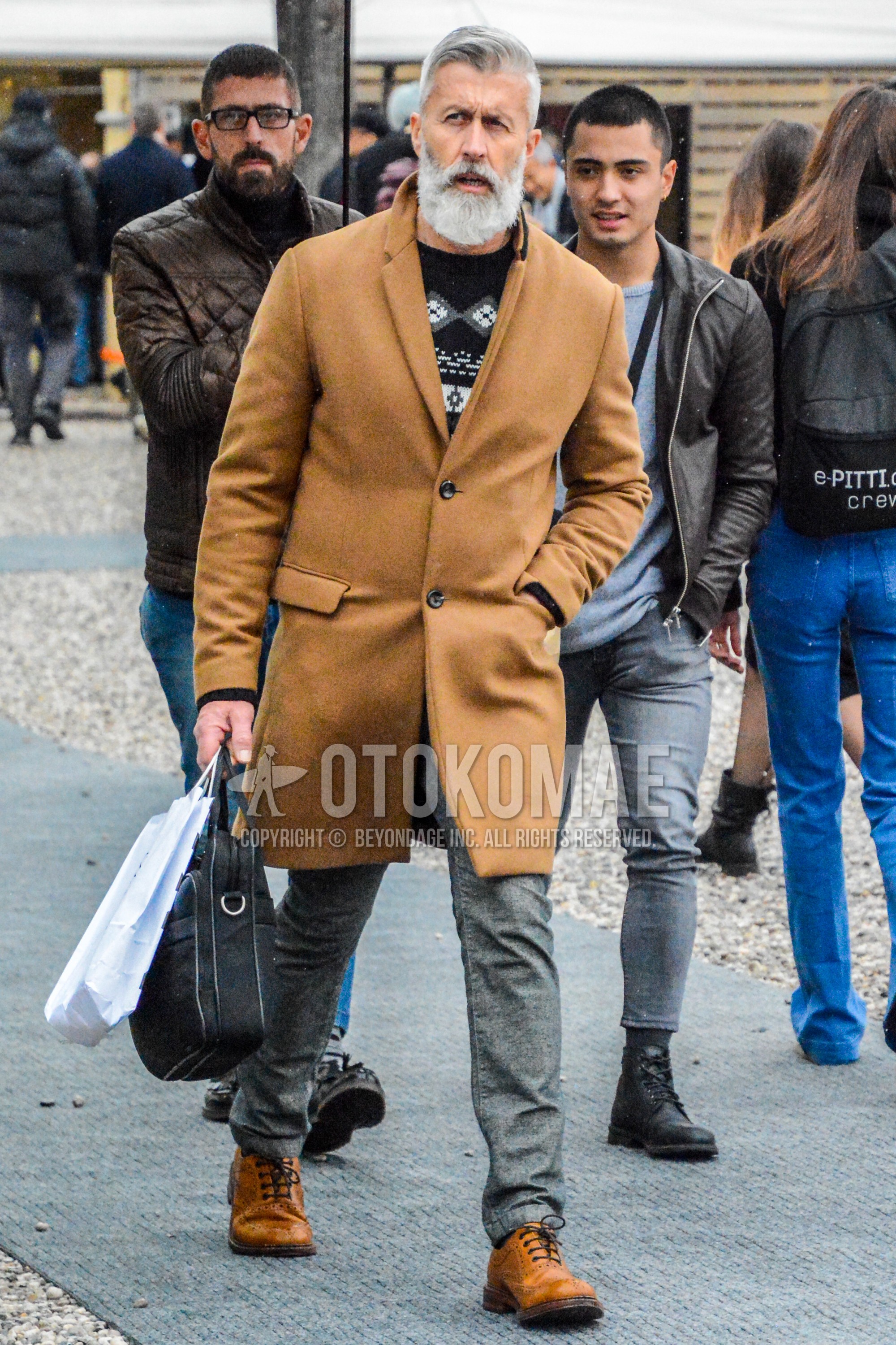 Men's autumn winter outfit with brown beige plain chester coat, black tops/innerwear sweater, gray plain cotton pants, beige wing-tip shoes leather shoes, black plain briefcase/handbag.