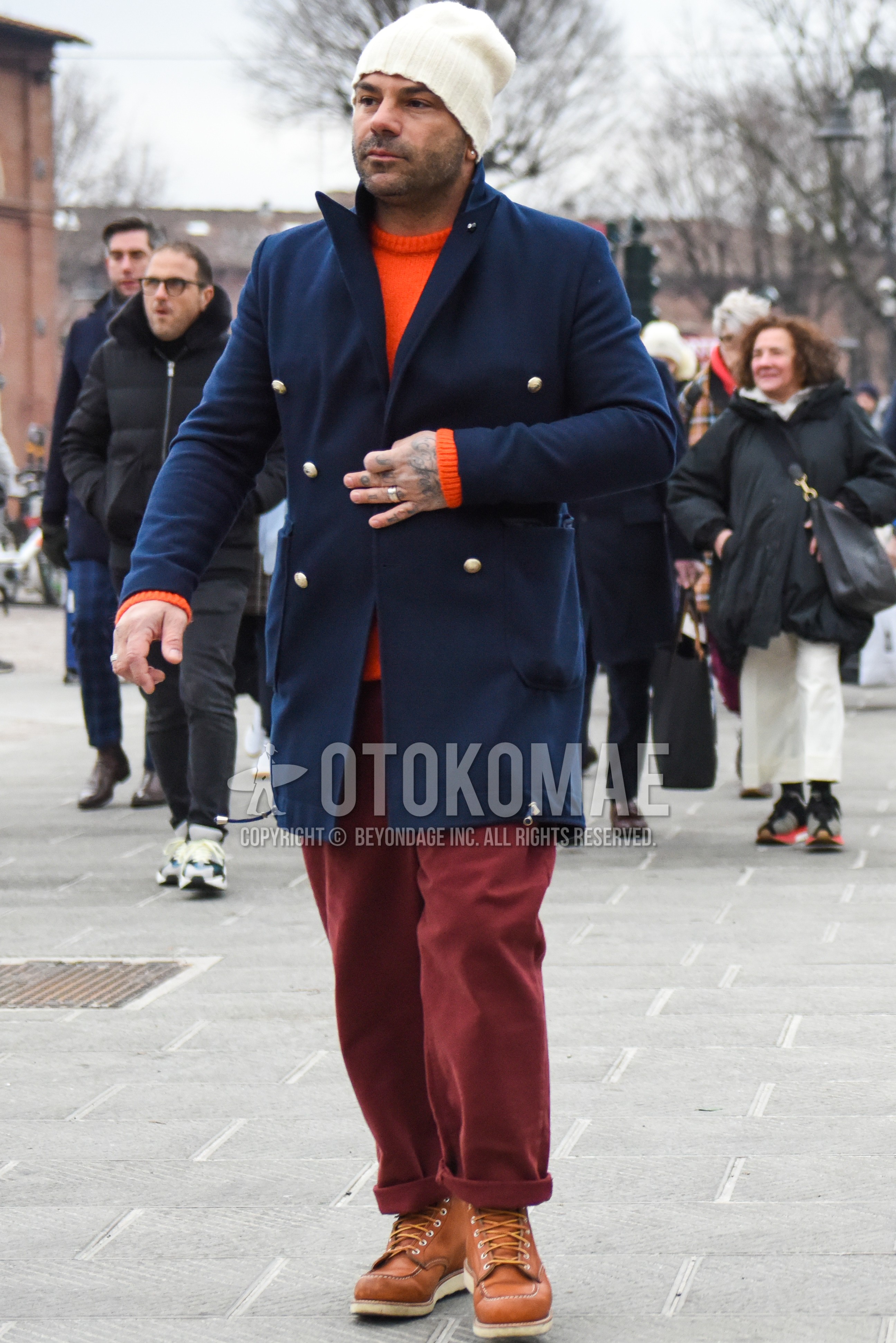Men's winter outfit with white plain knit cap, navy plain chester coat, orange plain sweater, red plain winter pants (corduroy,velour), brown work boots.