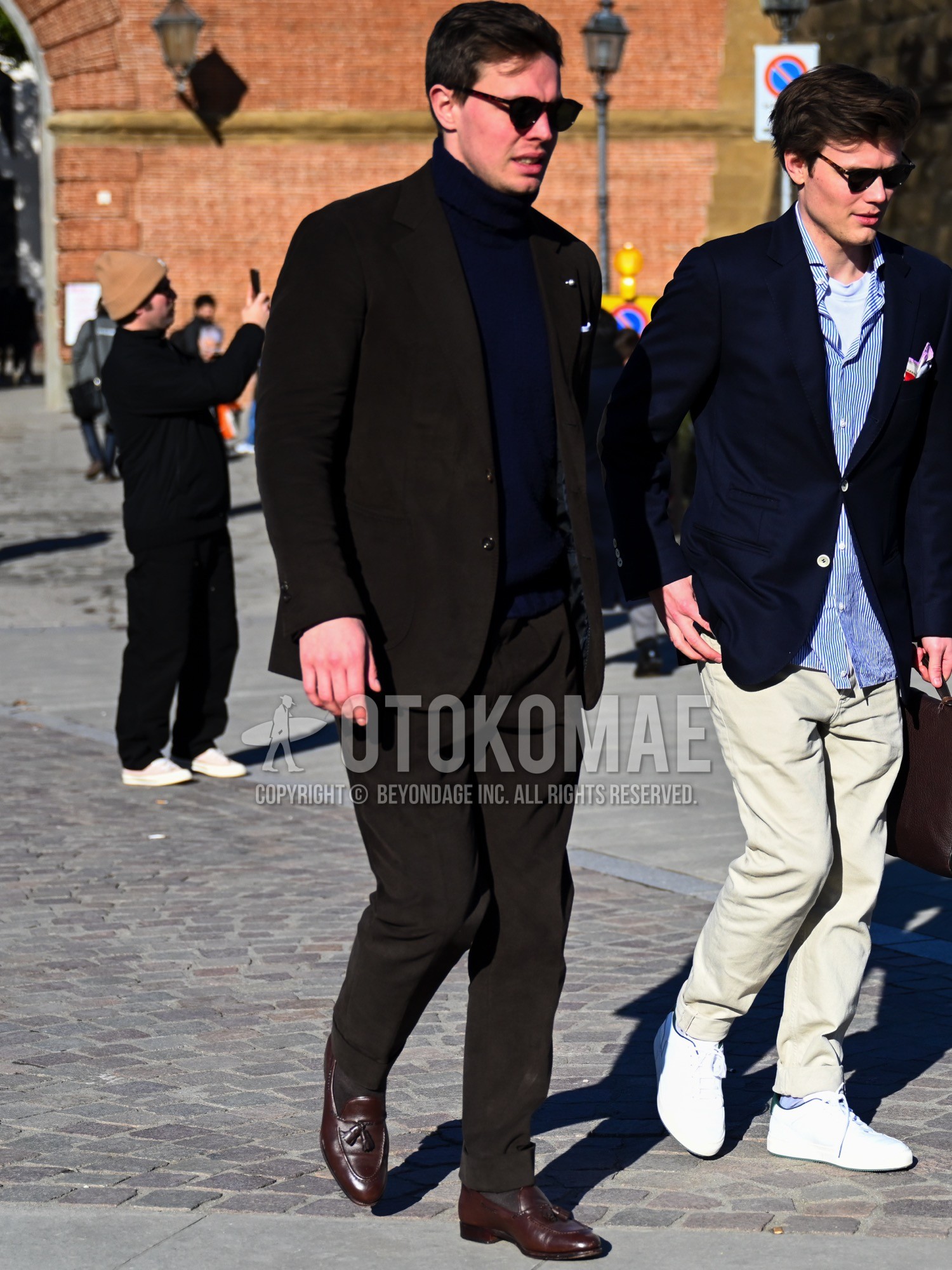 Men's spring autumn winter outfit with black plain sunglasses, navy plain turtleneck knit, brown plain socks, brown tassel loafers leather shoes, brown plain suit.