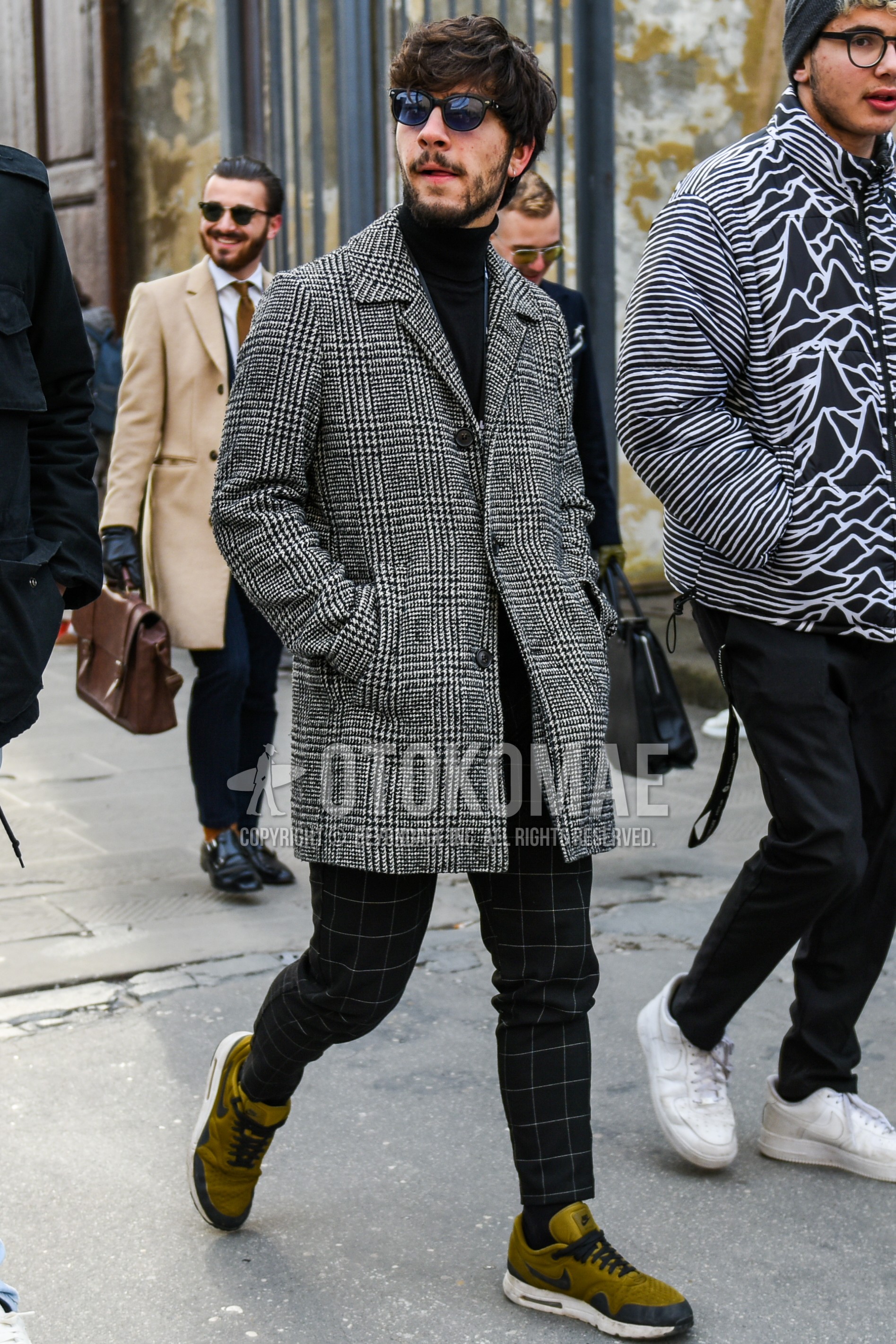 Men's autumn winter outfit with black plain sunglasses, gray plain stenkarrer coat, black plain turtleneck knit, black check slacks, black check ankle pants, olive green low-cut sneakers.