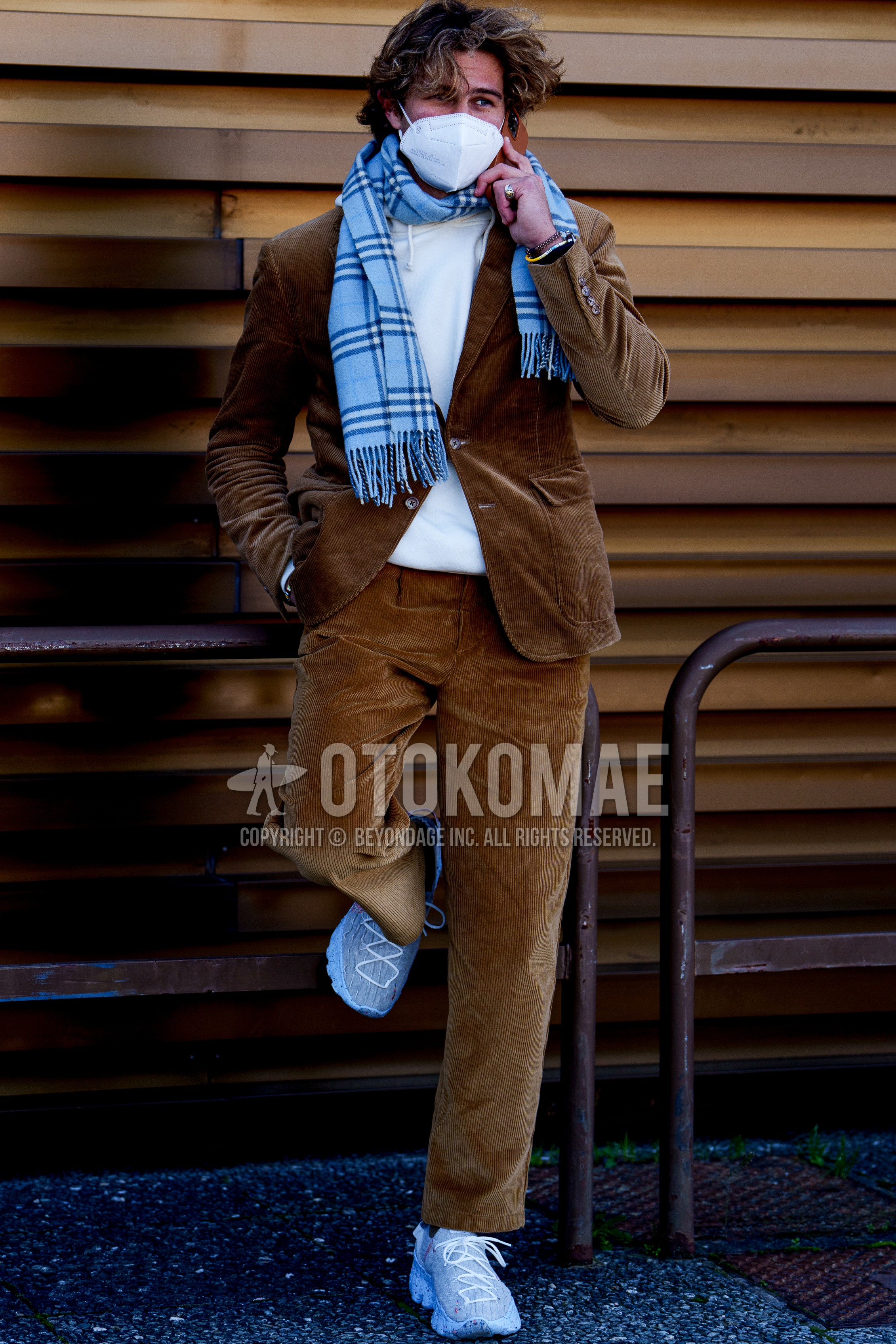 Men's autumn winter outfit with blue check scarf, brown plain tailored jacket, white plain hoodie, brown plain winter pants (corduroy,velour), white sneakers.