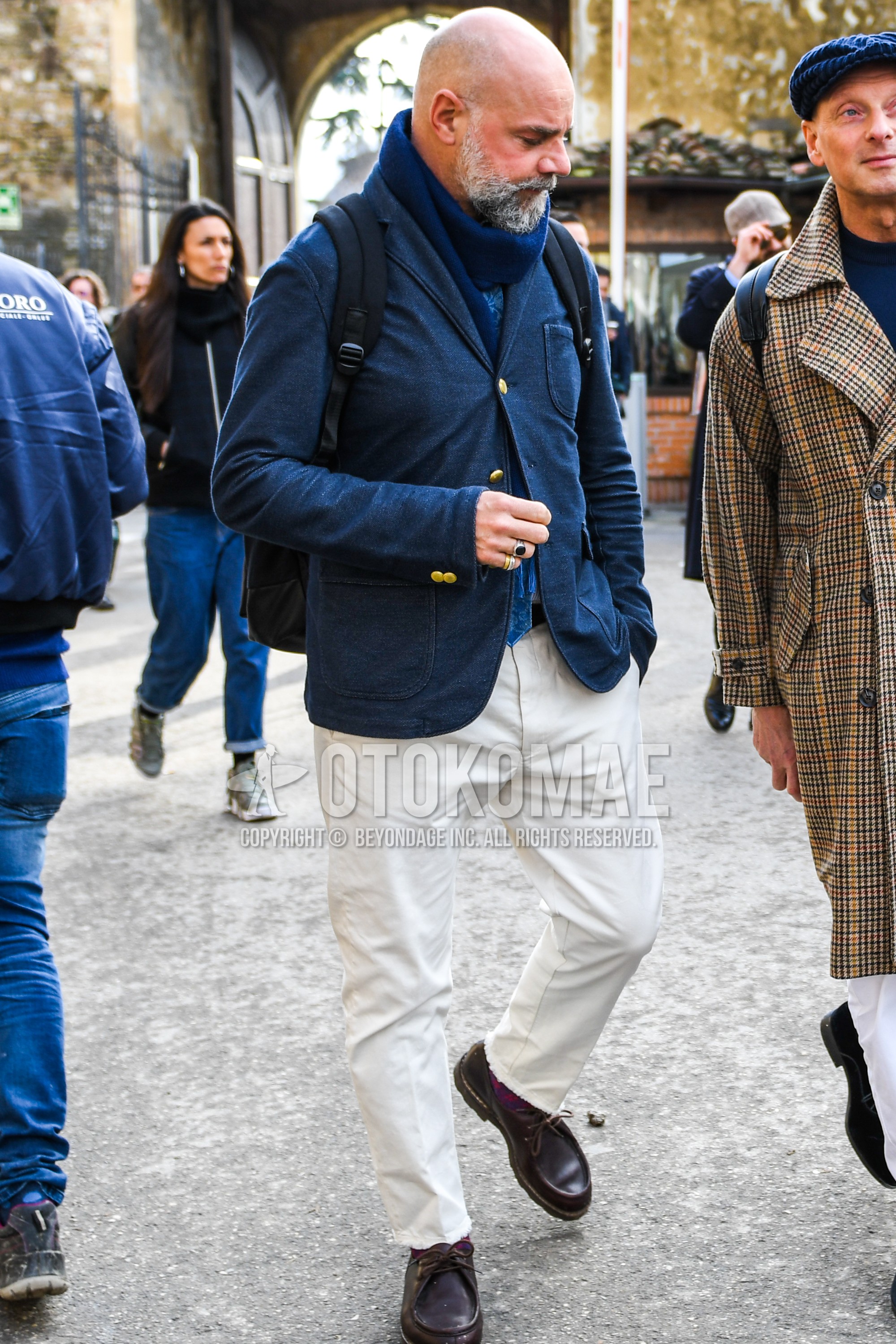 Men's winter outfit with blue plain scarf, navy plain tailored jacket, white plain cotton pants, brown  leather shoes.