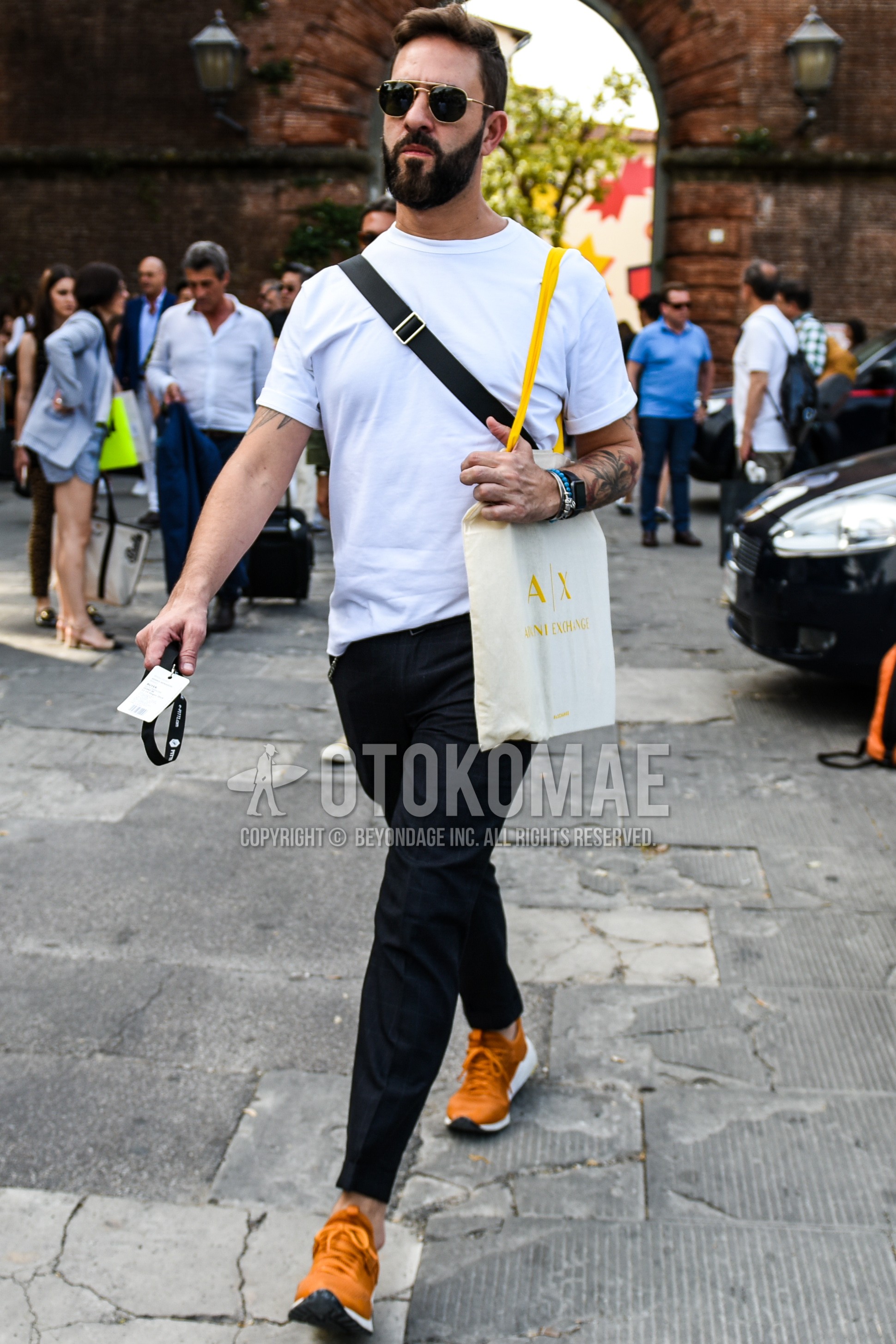Men's summer outfit with gold plain sunglasses, white plain t-shirt, black plain slacks, orange low-cut sneakers.