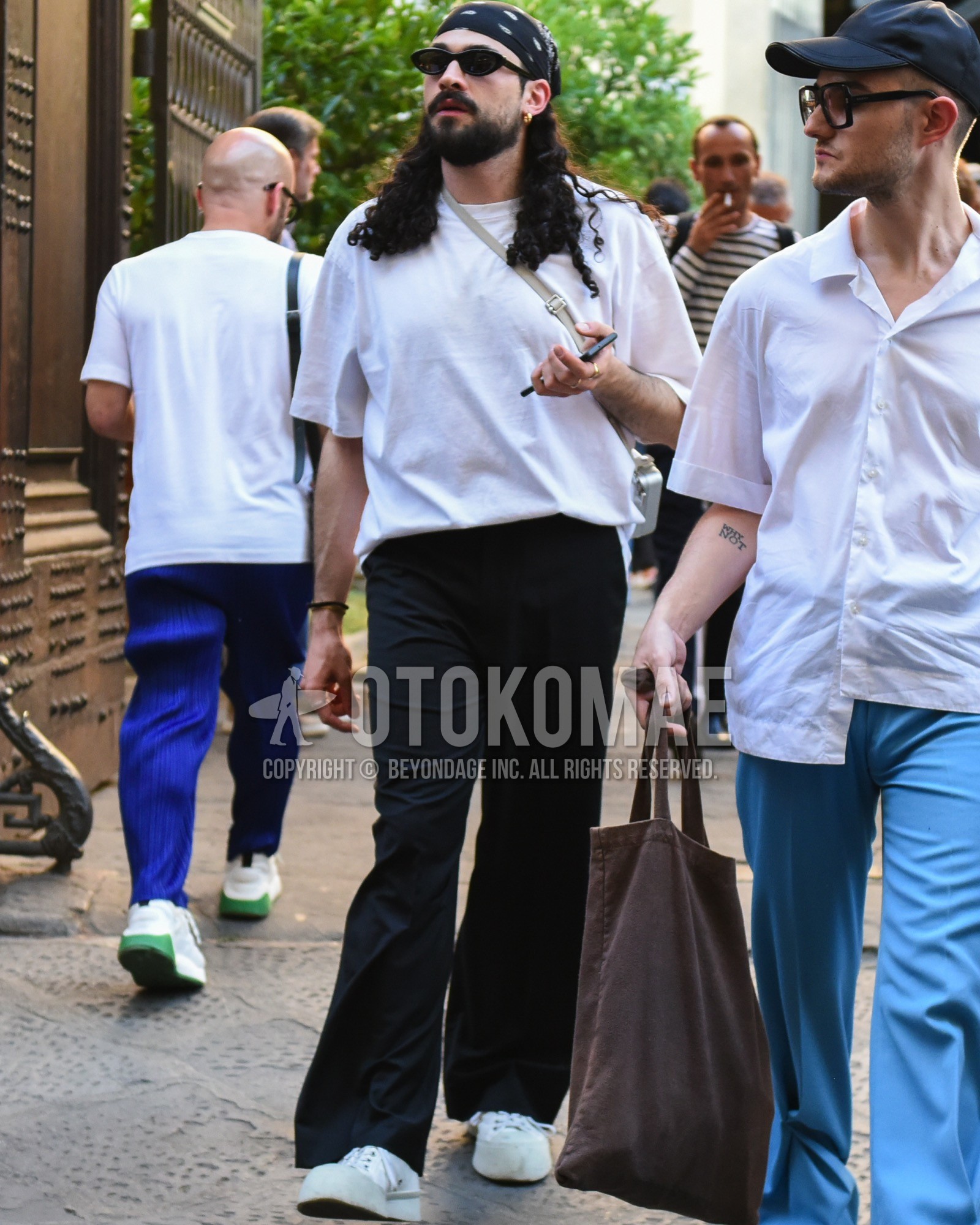 Men's spring summer outfit with black plain sunglasses, black scarf bandana/neckerchief, white plain t-shirt, black plain slacks, black plain wide pants, white low-cut sneakers.