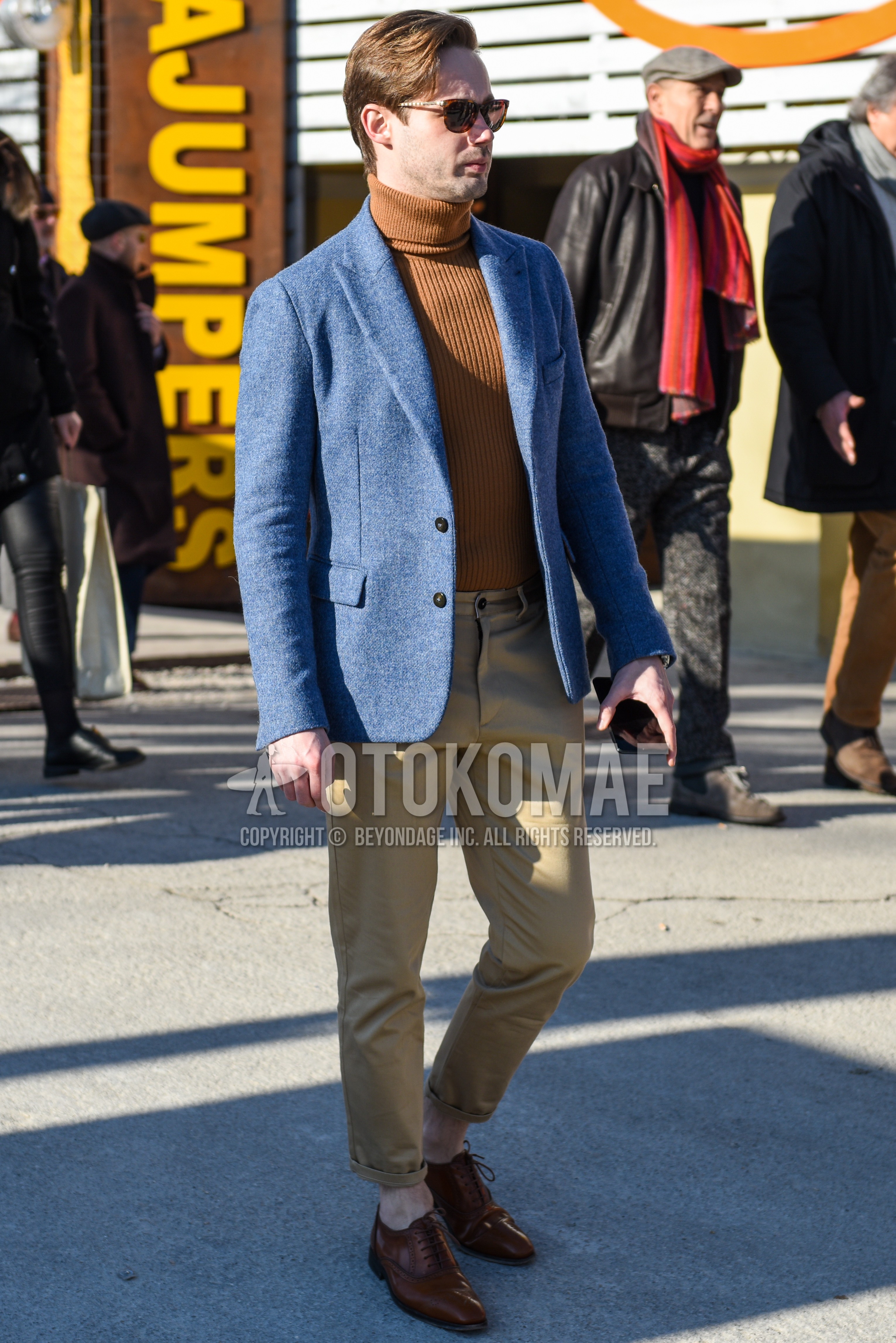 Men's spring autumn outfit with brown tortoiseshell sunglasses, gray plain tailored jacket, beige plain turtleneck knit, beige plain chinos, brown brogue shoes leather shoes.