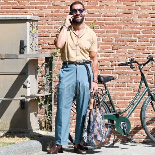 黒無地のサングラス、ブラウン無地のシャツ、ブラウン無地のメッシュベルト、ブルー無地のスラックス、ブラウングルカサンダルを合わせた春夏のメンズコーデ・着こなし。