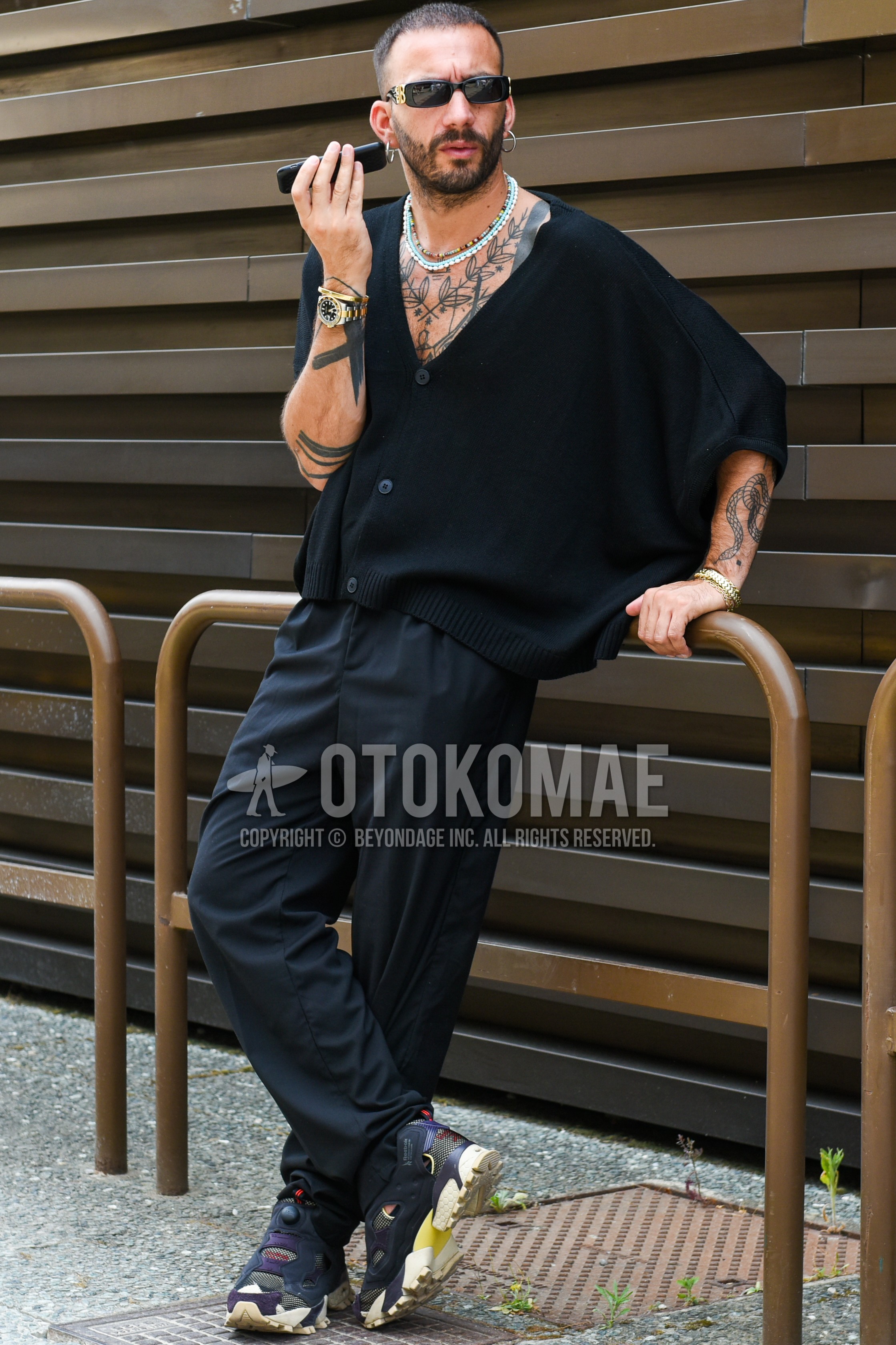 Men's spring summer outfit with black plain sunglasses, black plain cardigan, black plain slacks, black low-cut sneakers.