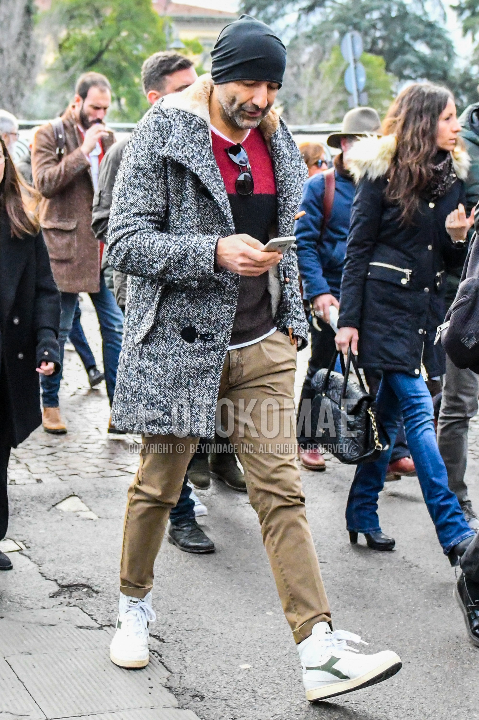Men's winter outfit with plain knit cap, gray plain outerwear, red multi-color plain sweater, brown plain chinos, white high-cut sneakers.