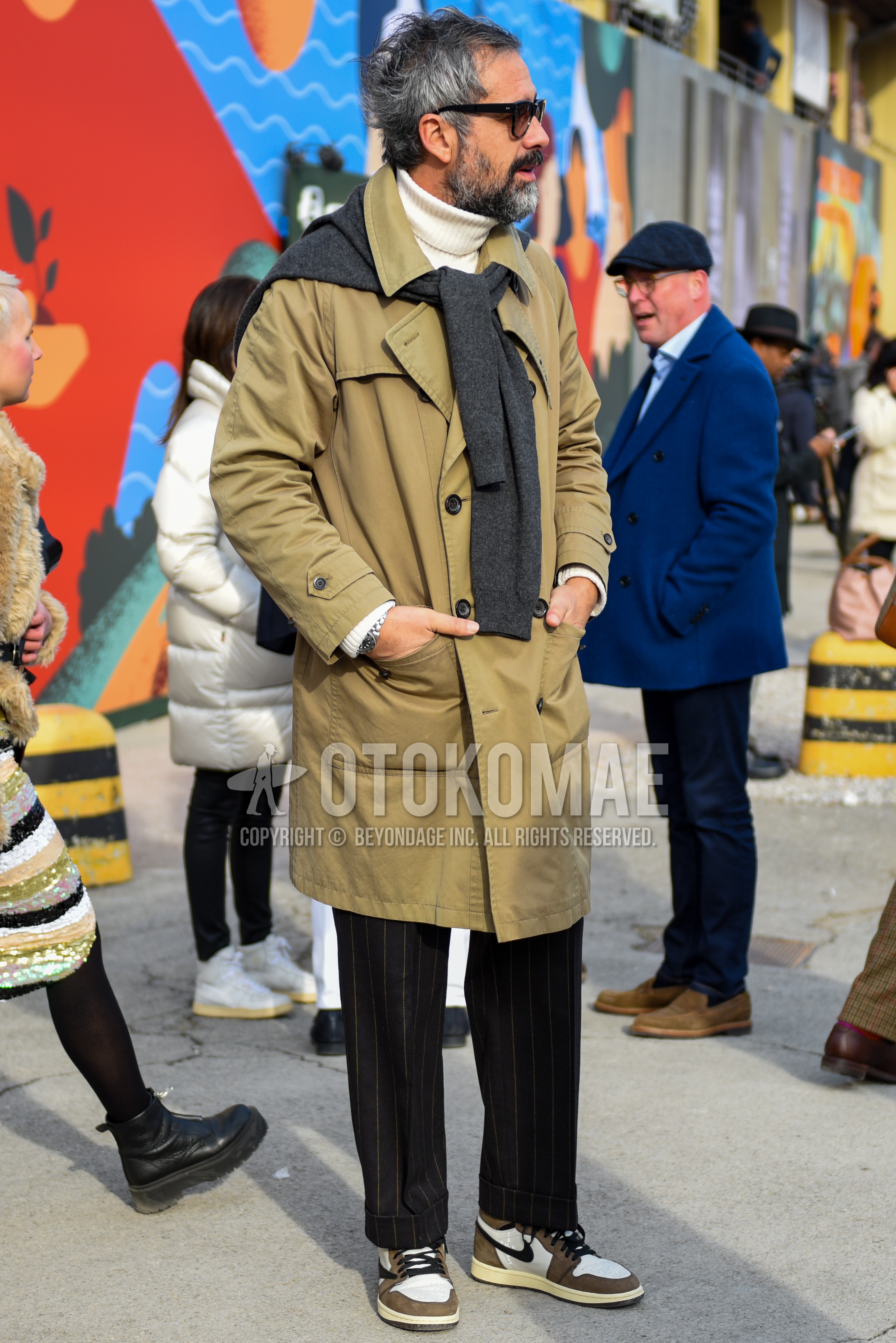 Men's autumn winter outfit with black plain sunglasses, beige plain trench coat, white plain turtleneck knit, gray plain sweater, dark gray stripes slacks, beige white low-cut sneakers.