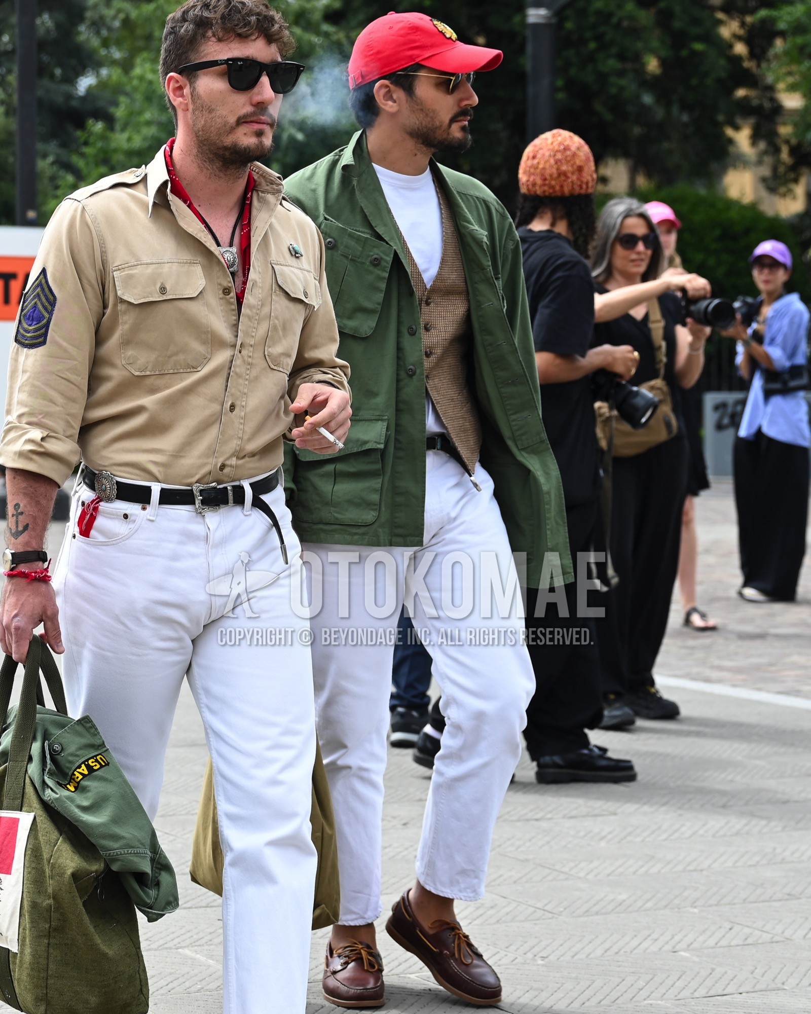 Men's spring summer autumn outfit with red deca logo baseball cap, olive green plain military jacket, brown plain casual vest, white plain t-shirt, brown plain leather belt, white plain denim/jeans, brown moccasins/deck shoes leather shoes.