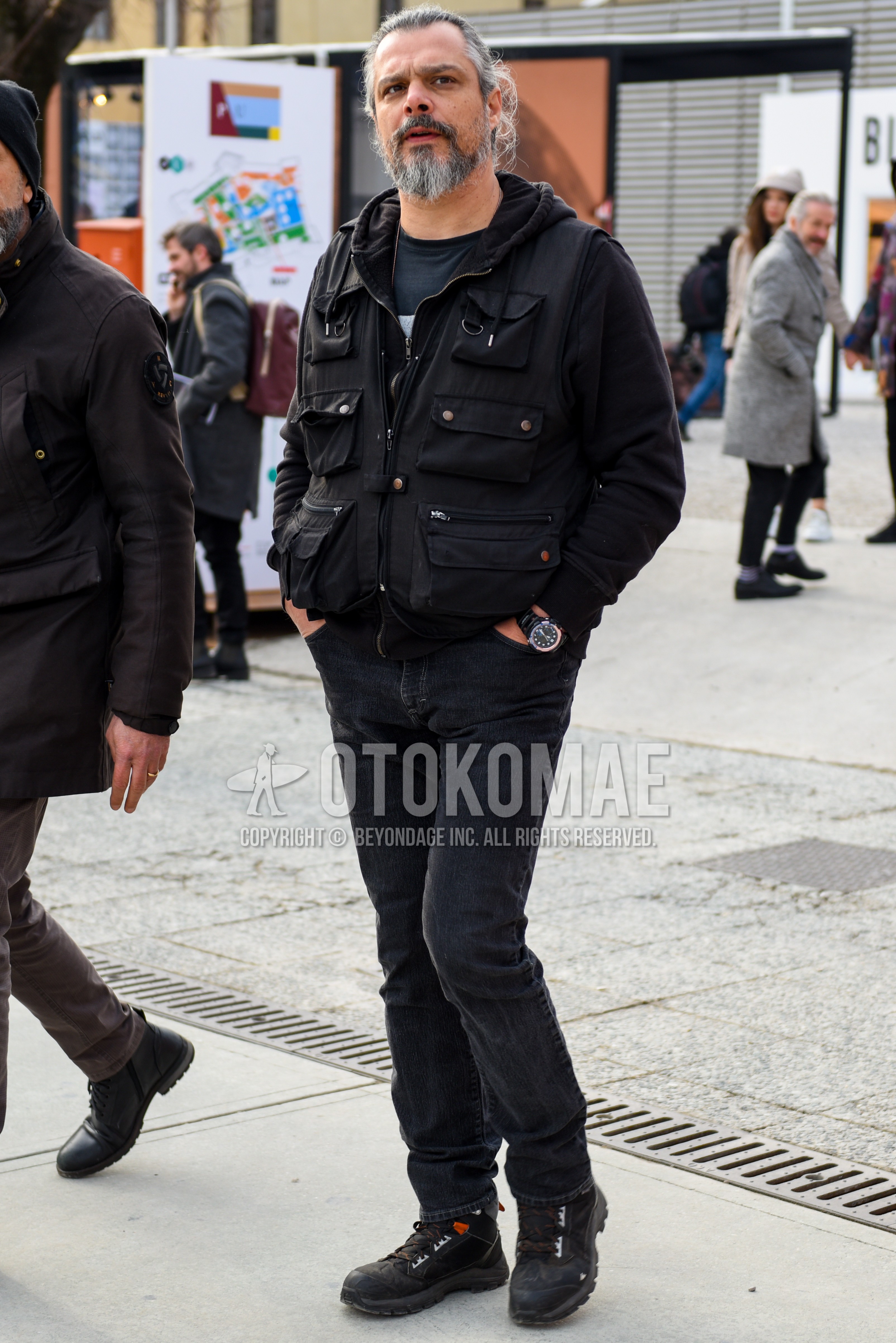 Men's autumn winter outfit with black graphic long sleeve t-shirt, black plain casual vest, black plain denim/jeans, black  boots.