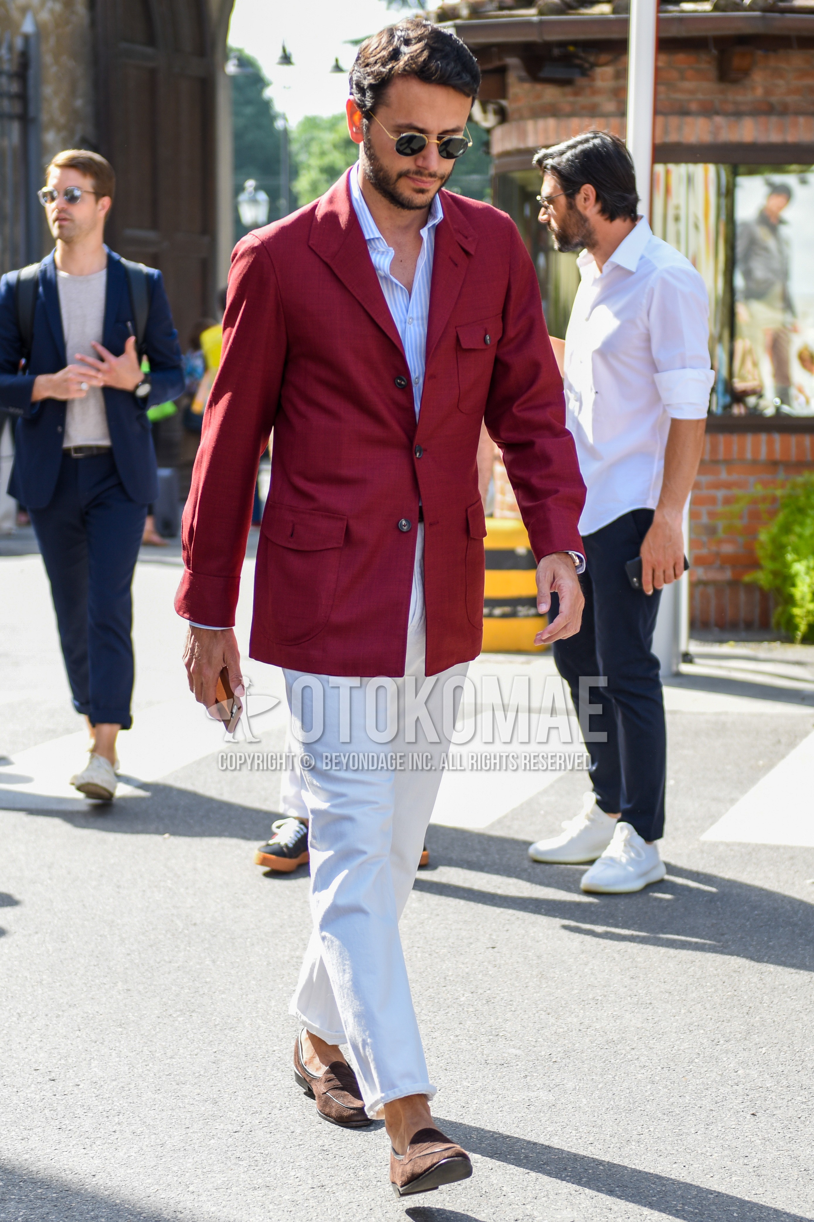 Men's spring summer autumn outfit with gold plain sunglasses, red plain tailored jacket, white stripes shirt, white plain cotton pants, brown coin loafers leather shoes.
