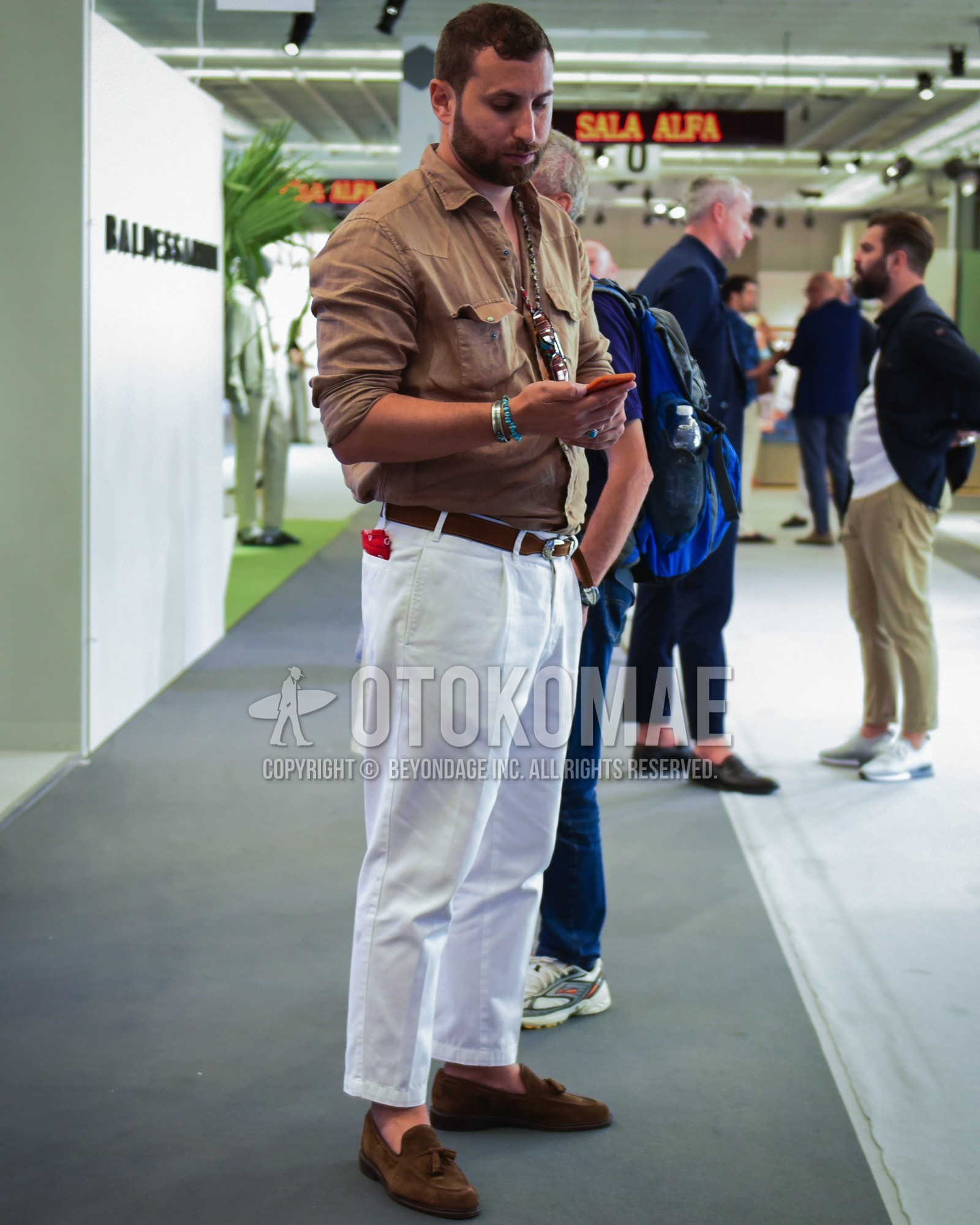 Men's spring summer outfit with brown plain shirt, brown plain leather belt, white plain cotton pants, brown tassel loafers leather shoes.