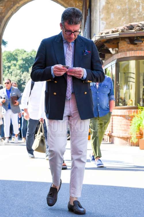 無地のメガネ、ネイビー無地のテーラードジャケット、水色無地のシャツ、ベージュ無地のチノパン、無地のアンクルパンツ、黒タッセルローファーの革靴、レッドネクタイのネクタイを合わせた春夏秋のメンズコーデ・着こなし。