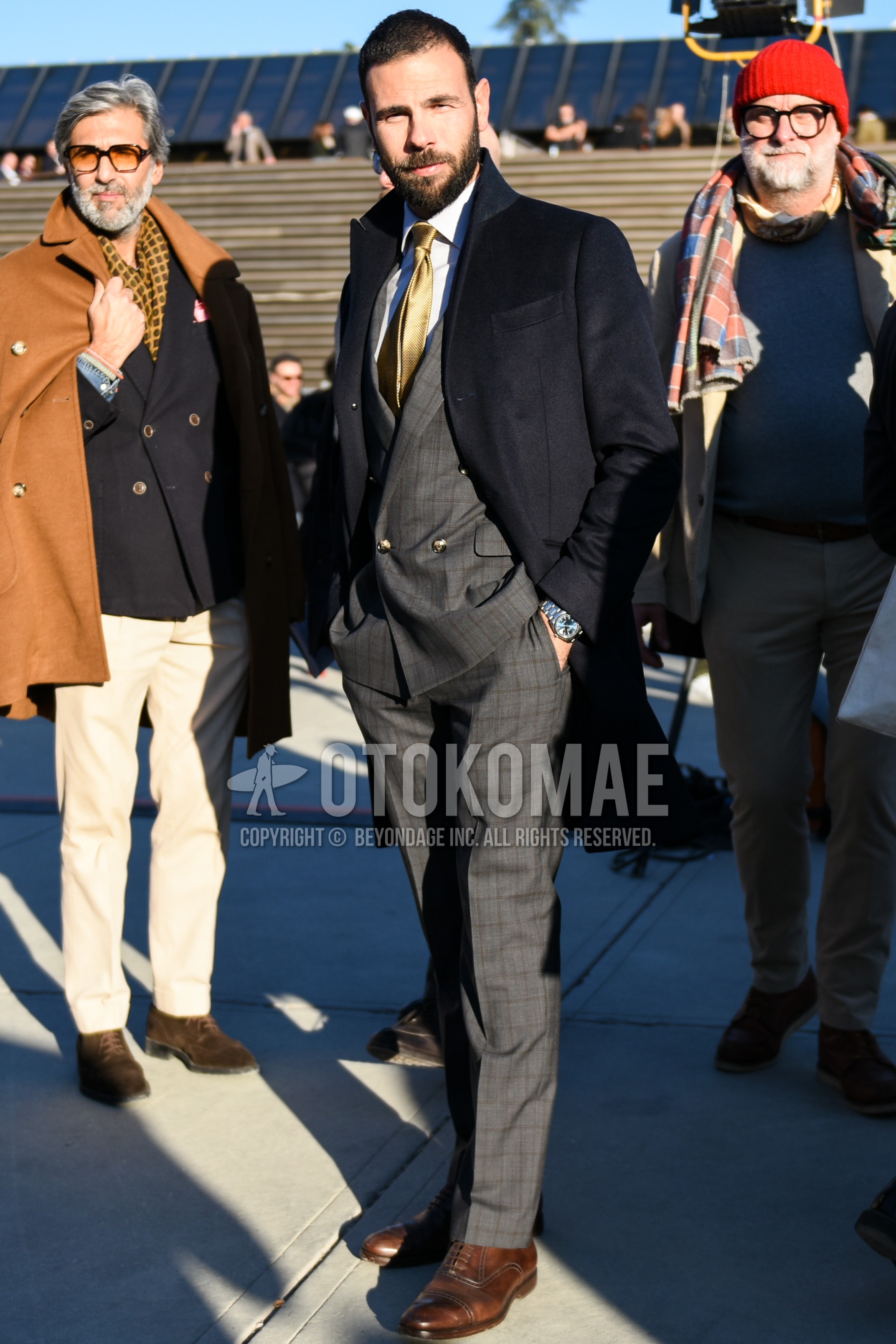 Men's autumn winter outfit with black plain chester coat, white plain shirt, brown brogue shoes leather shoes, gray check suit, gold plain necktie.