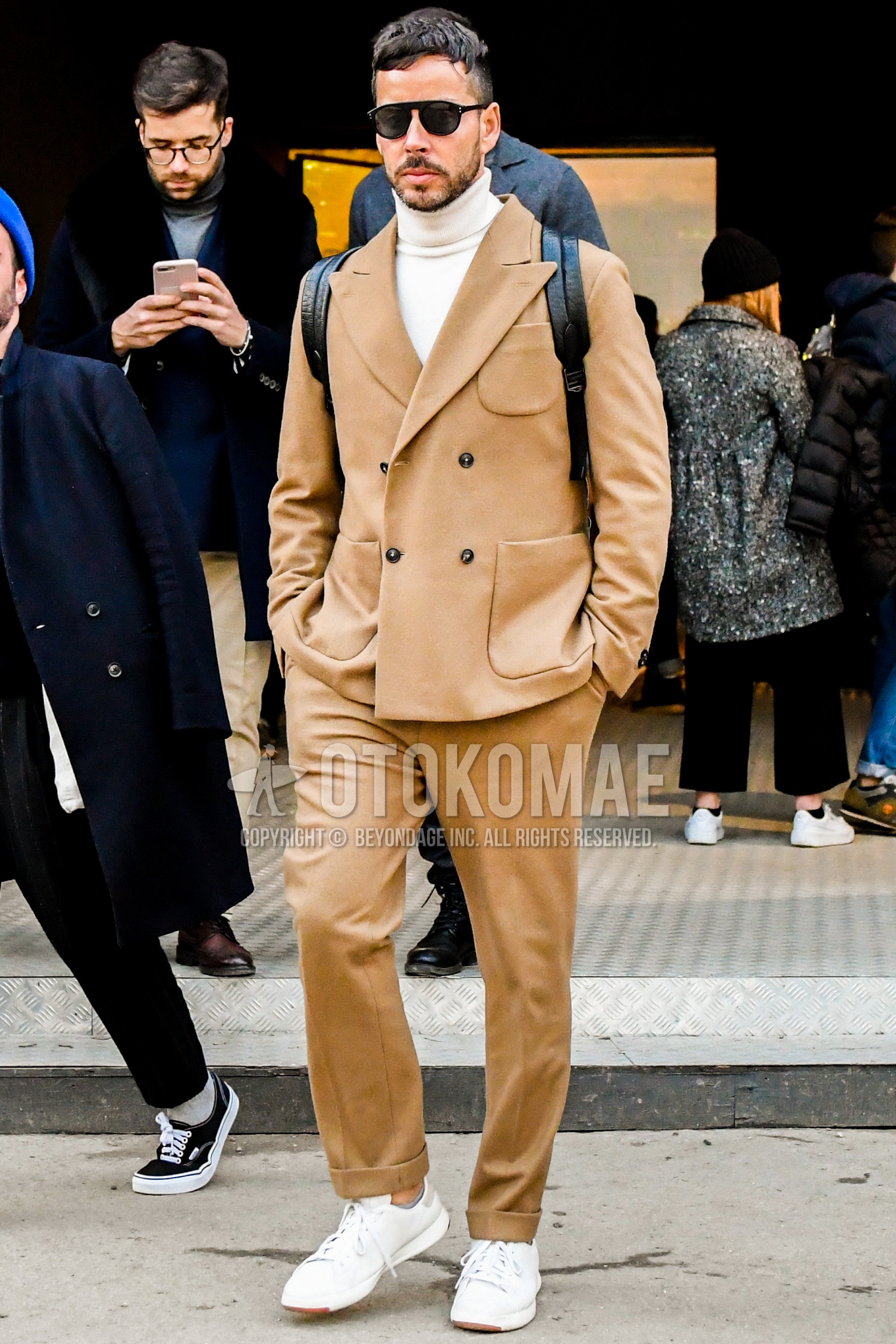 Men's winter outfit with plain sunglasses, white plain turtleneck knit, white low-cut sneakers, brown plain suit.