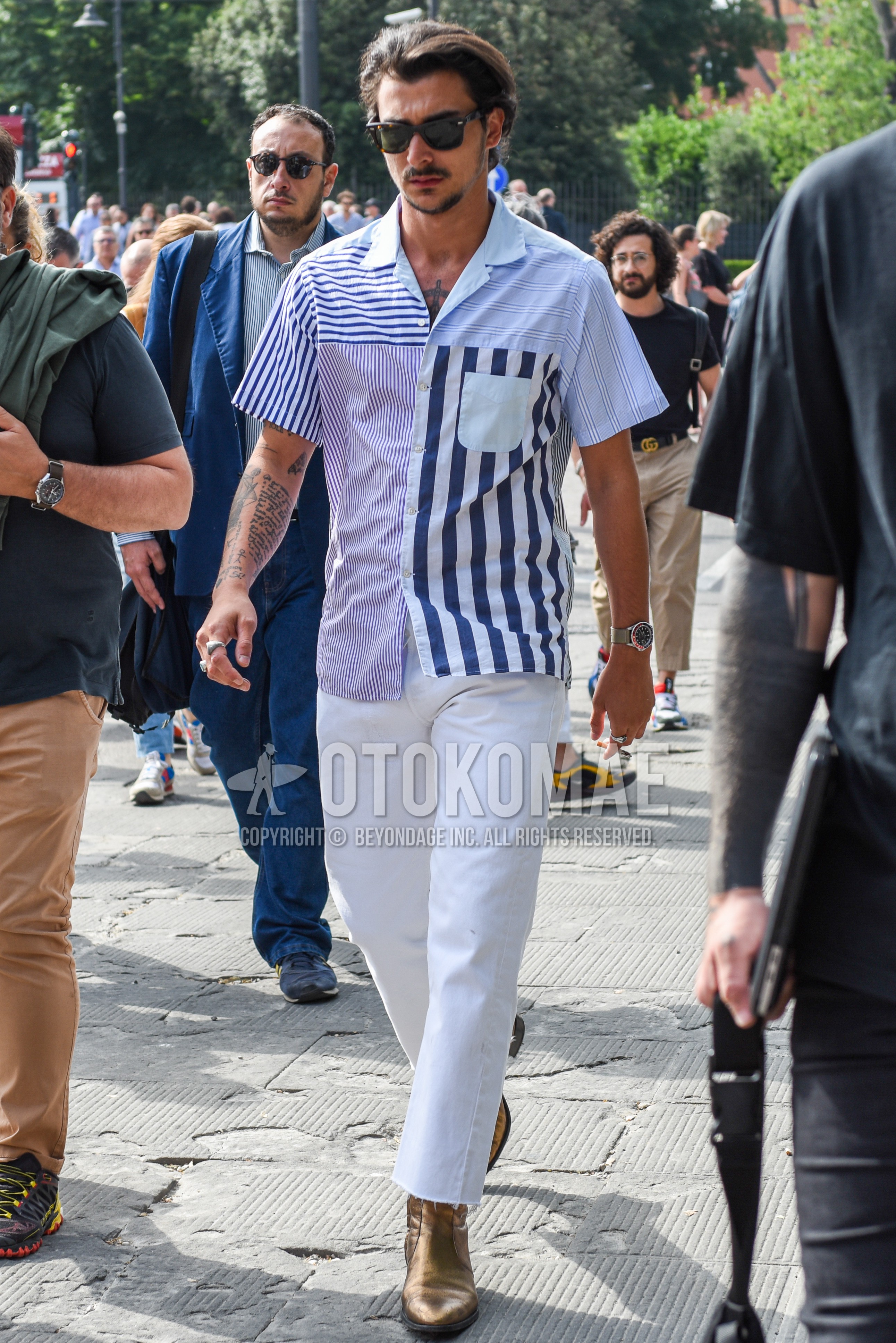 Men's summer outfit with brown tortoiseshell sunglasses, light blue tops/innerwear shirt, white plain denim/jeans, gold side-gore boots.