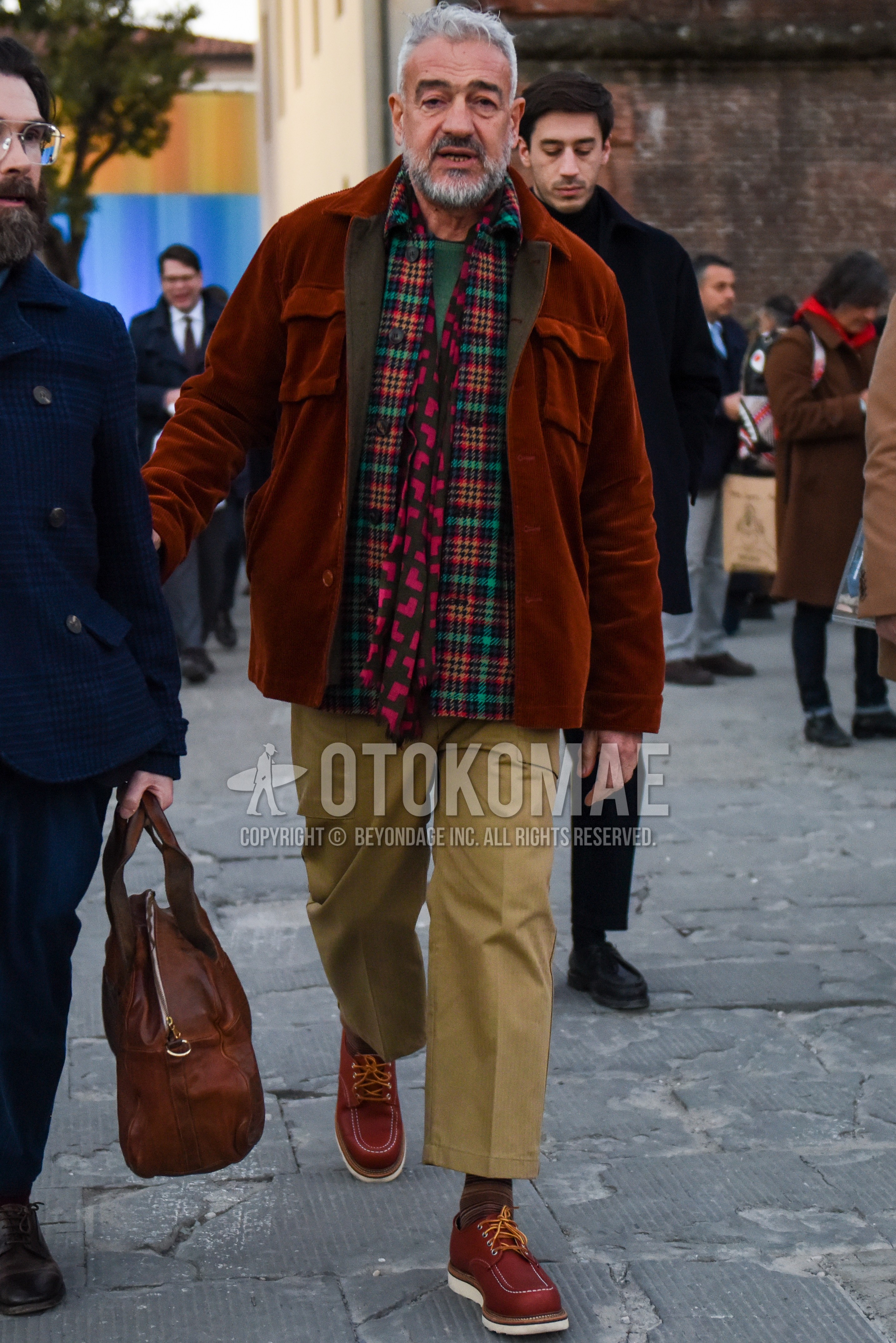 Men's autumn winter outfit with red gray scarf scarf, brown plain shirt jacket, multi-color check shirt, green plain sweater, beige plain chinos, beige plain cropped pants, brown horizontal stripes socks, brown  leather shoes.
