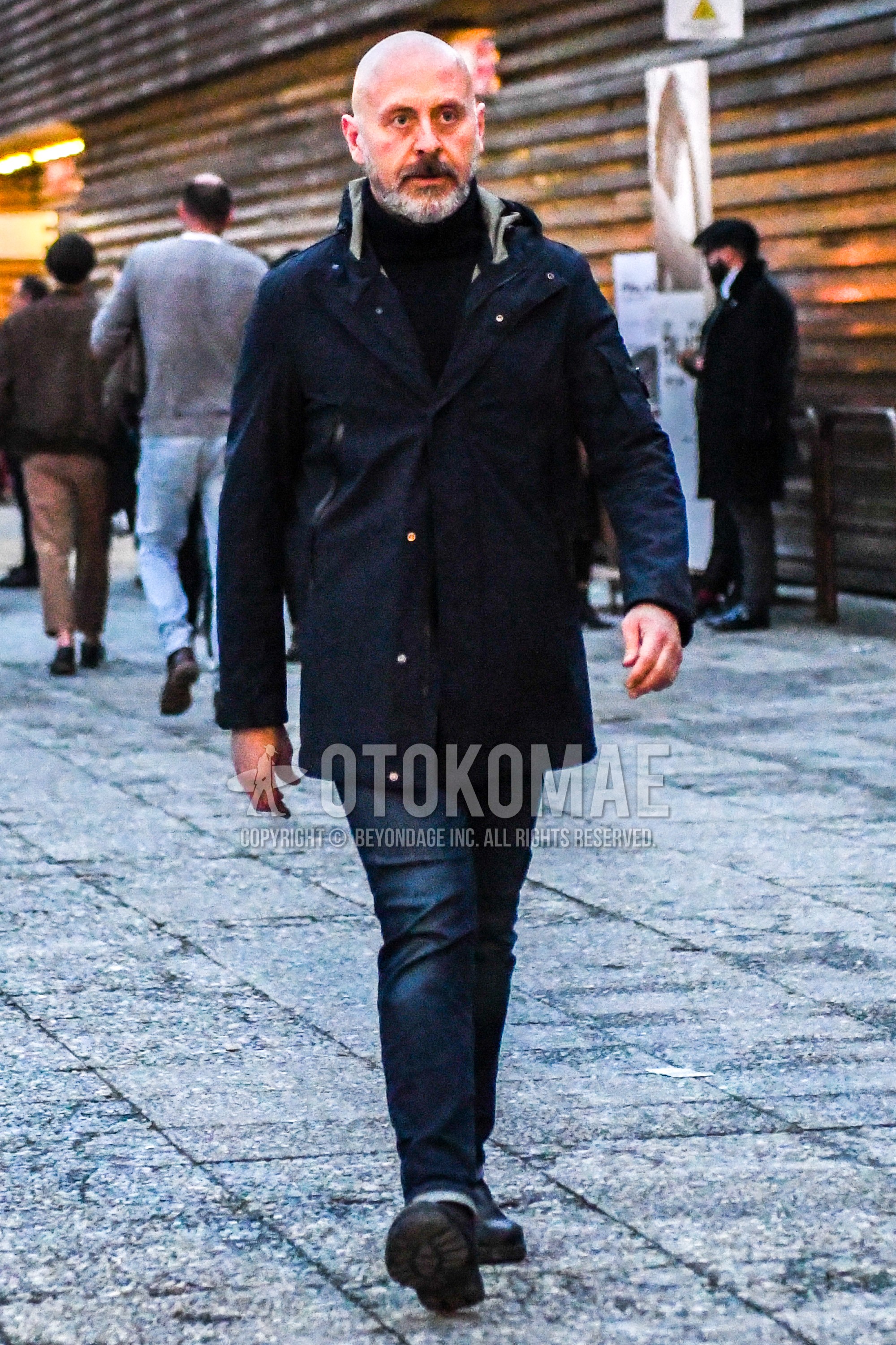 Men's winter outfit with black plain hooded coat, black plain turtleneck knit, navy plain denim/jeans.