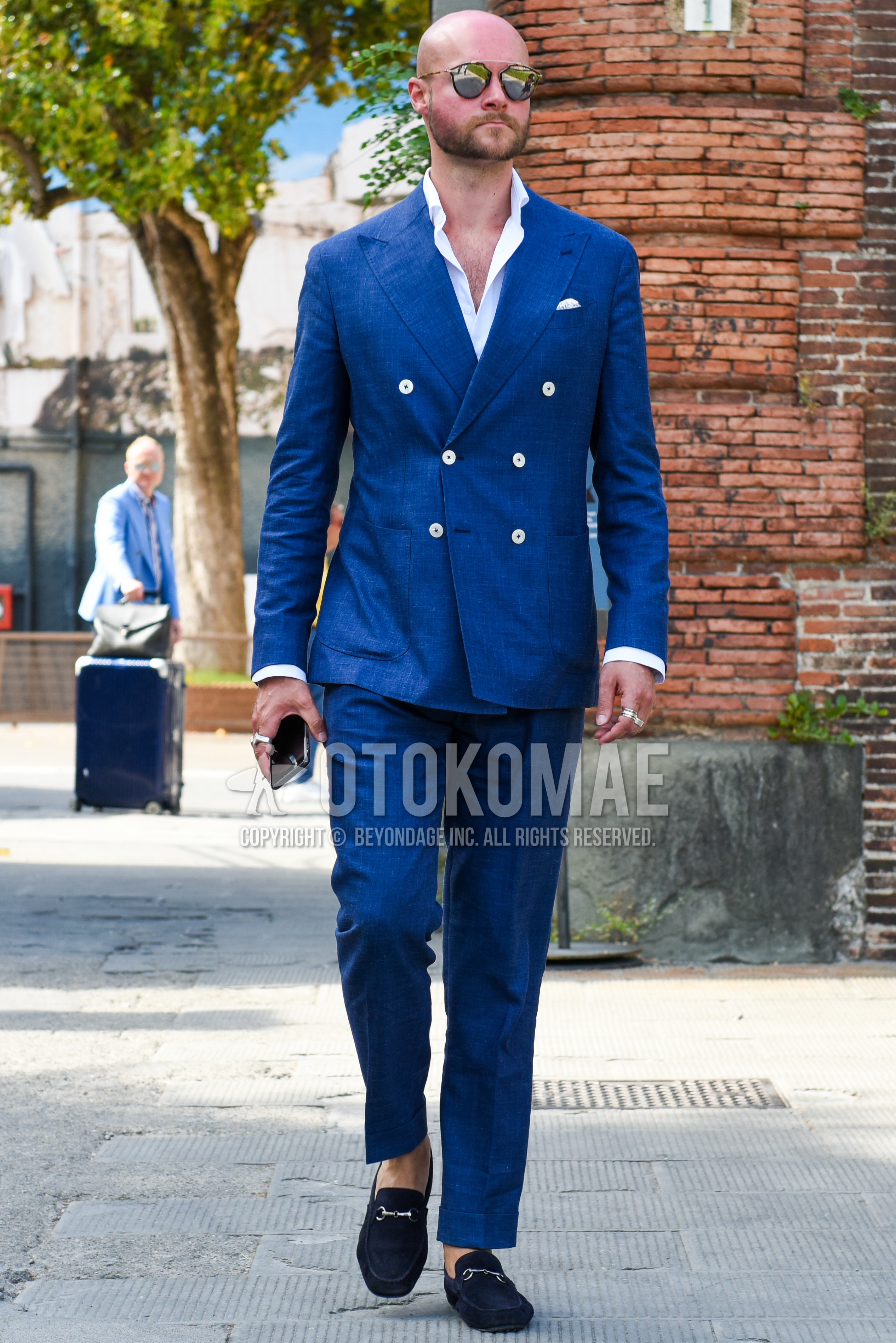 Men's spring summer autumn outfit with brown tortoiseshell sunglasses, white plain shirt, black bit loafers leather shoes, black suede shoes leather shoes, navy plain suit.