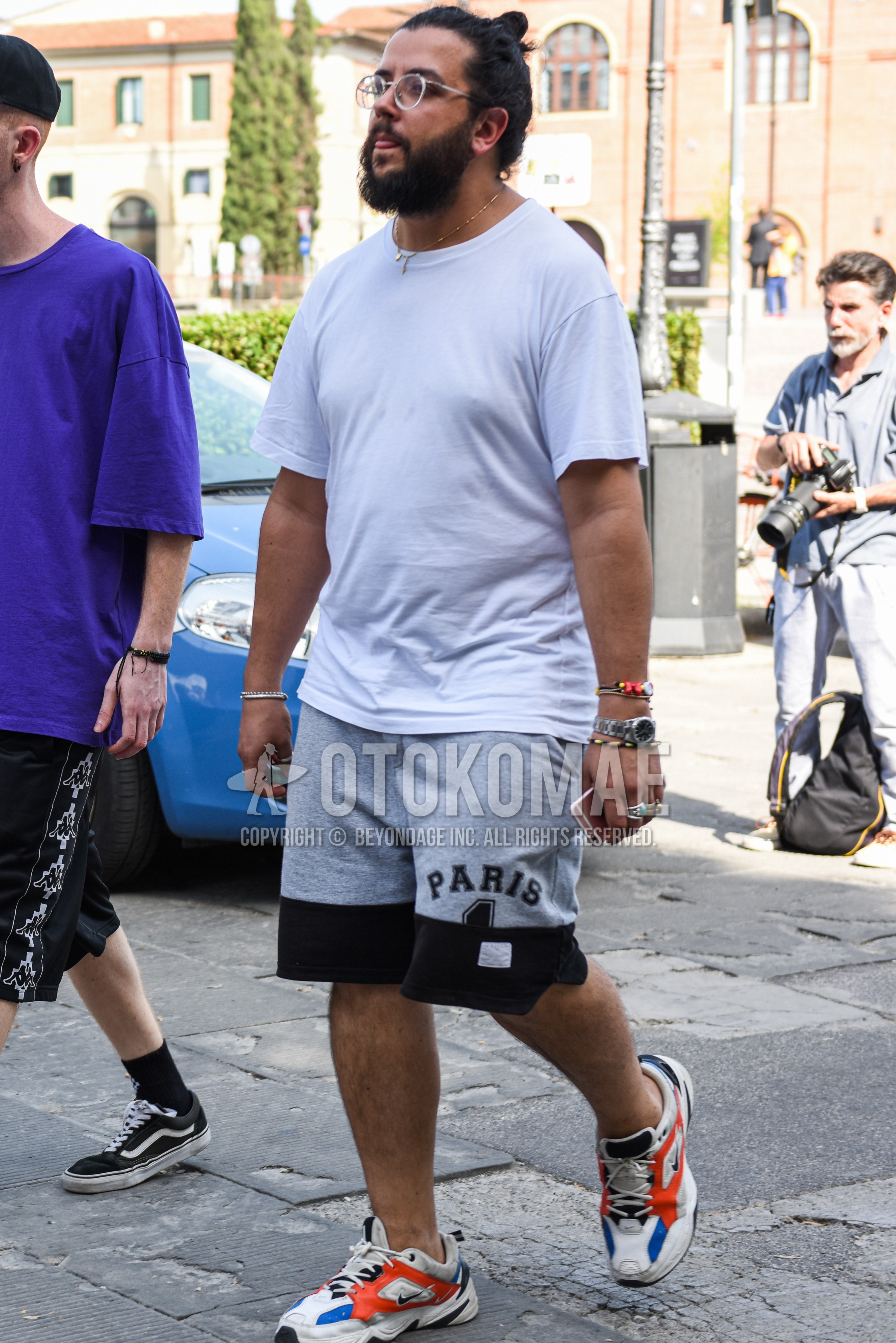 Men's summer outfit with silver plain glasses, white plain t-shirt, gray plain short pants, multi-color low-cut sneakers.