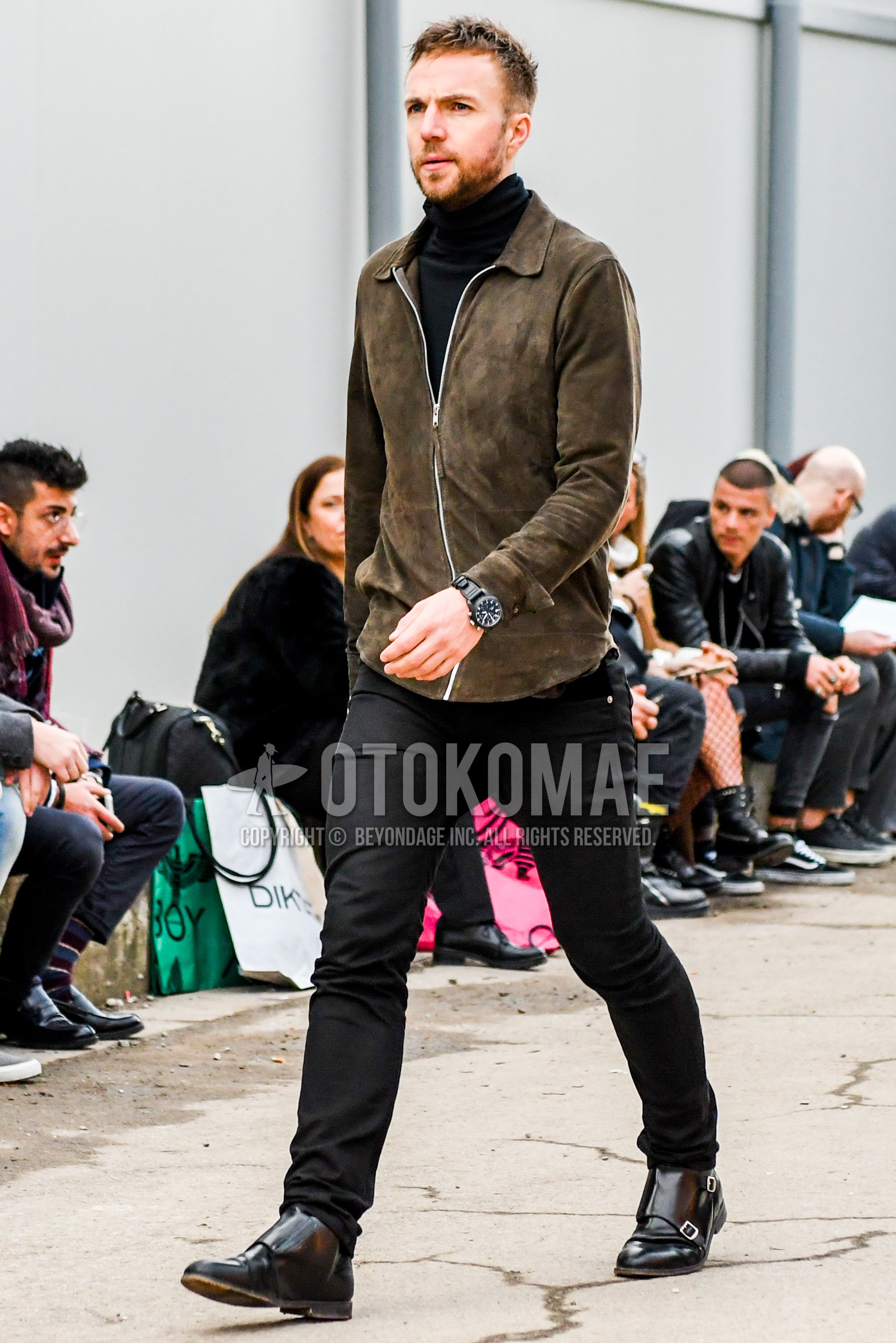 Men's winter outfit with brown plain leather jacket, black plain turtleneck knit, black plain cotton pants, black monk shoes leather shoes.