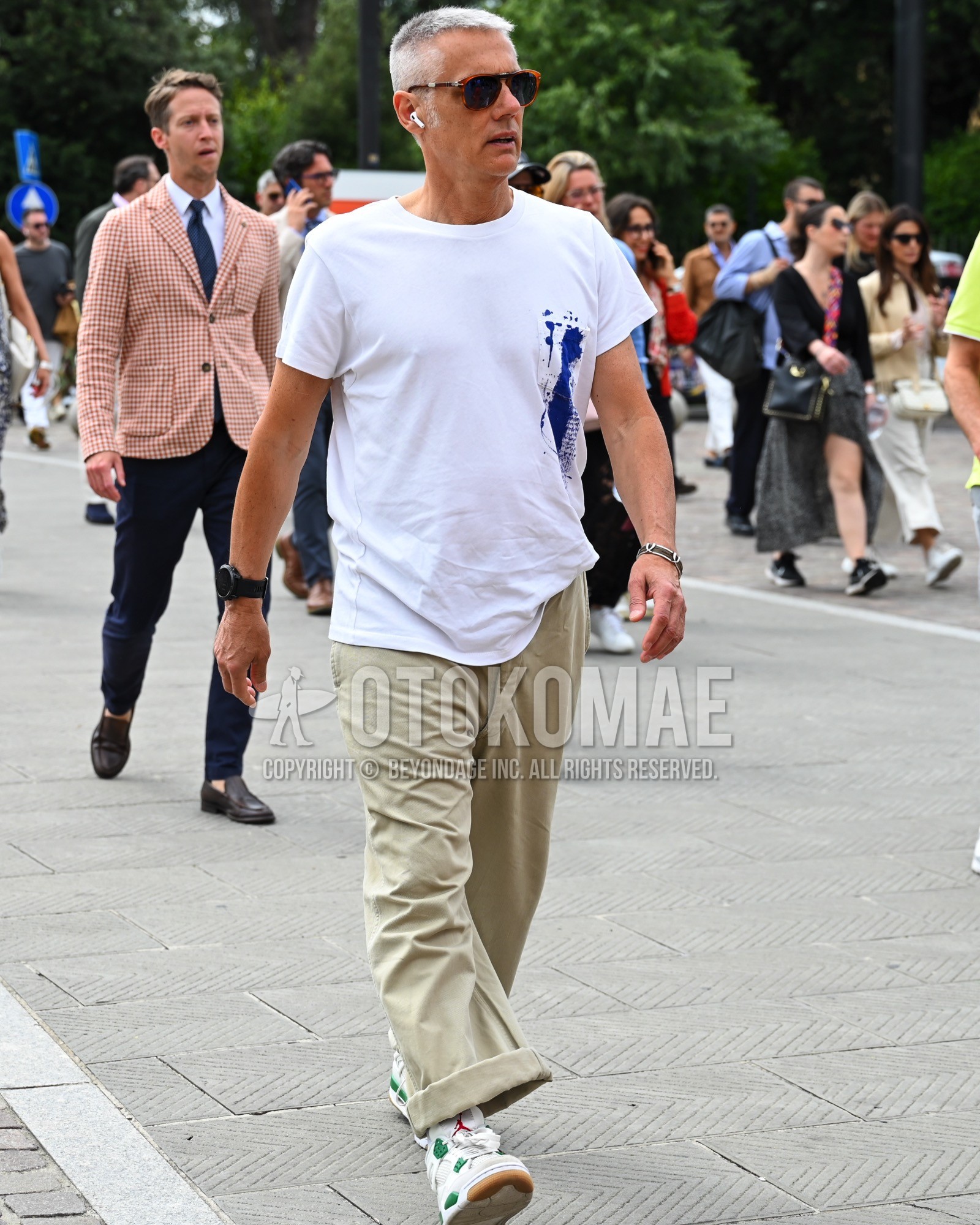 Men's spring summer outfit with black plain sunglasses, white one point t-shirt, beige plain chinos, white high-cut sneakers.
