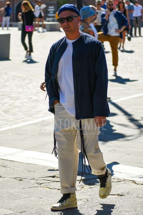 ネイビー無地のニットキャップ、ウェリントンの黒無地のサングラス、ダークグレー無地のアウター、白無地のTシャツ、ベージュ無地のチノパン、ナイキのベージュハイカットのスニーカーを合わせた春夏秋のメンズコーデ・着こなし。
