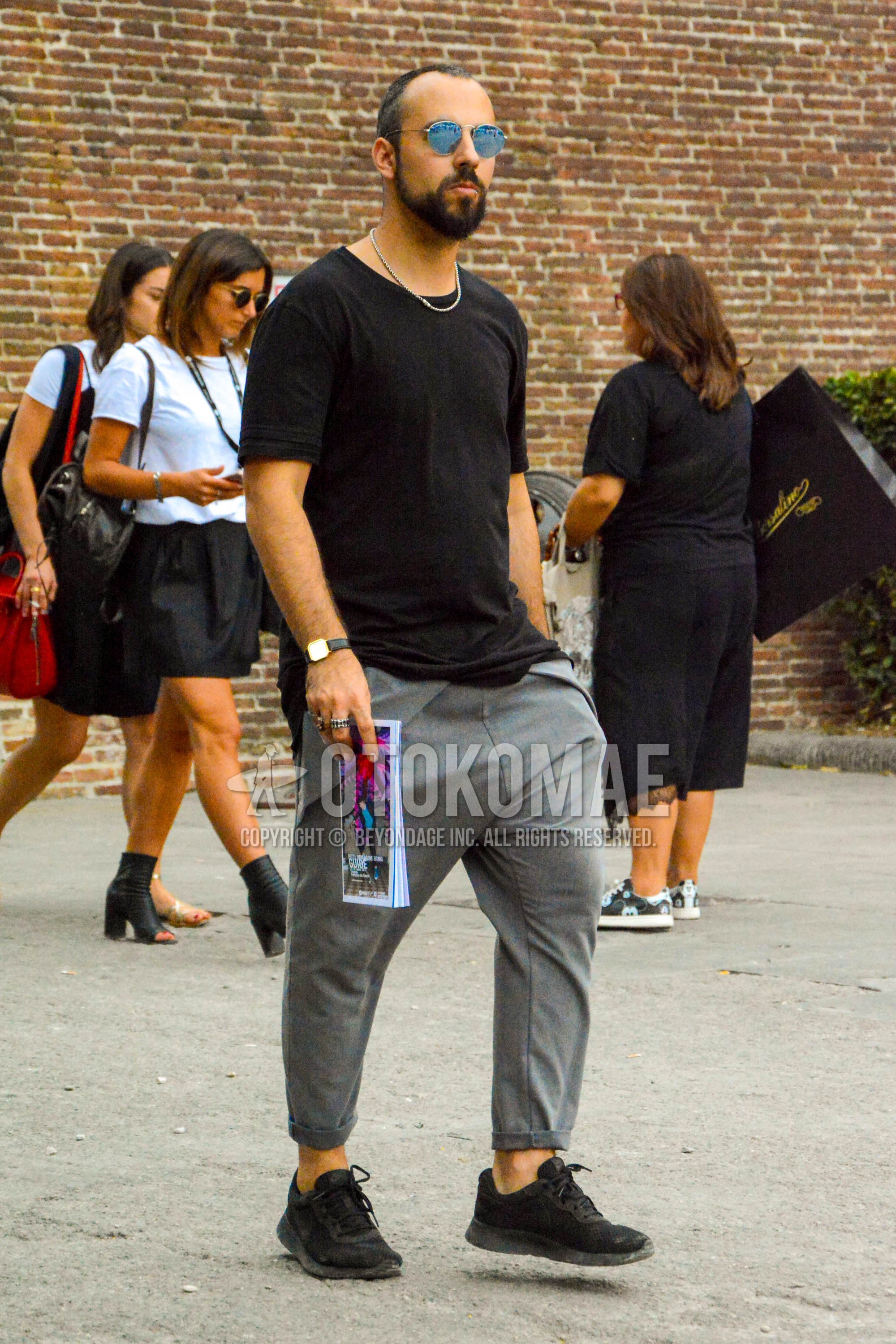 Men's summer outfit with plain sunglasses, black plain t-shirt, gray plain suluell pants, black low-cut sneakers.