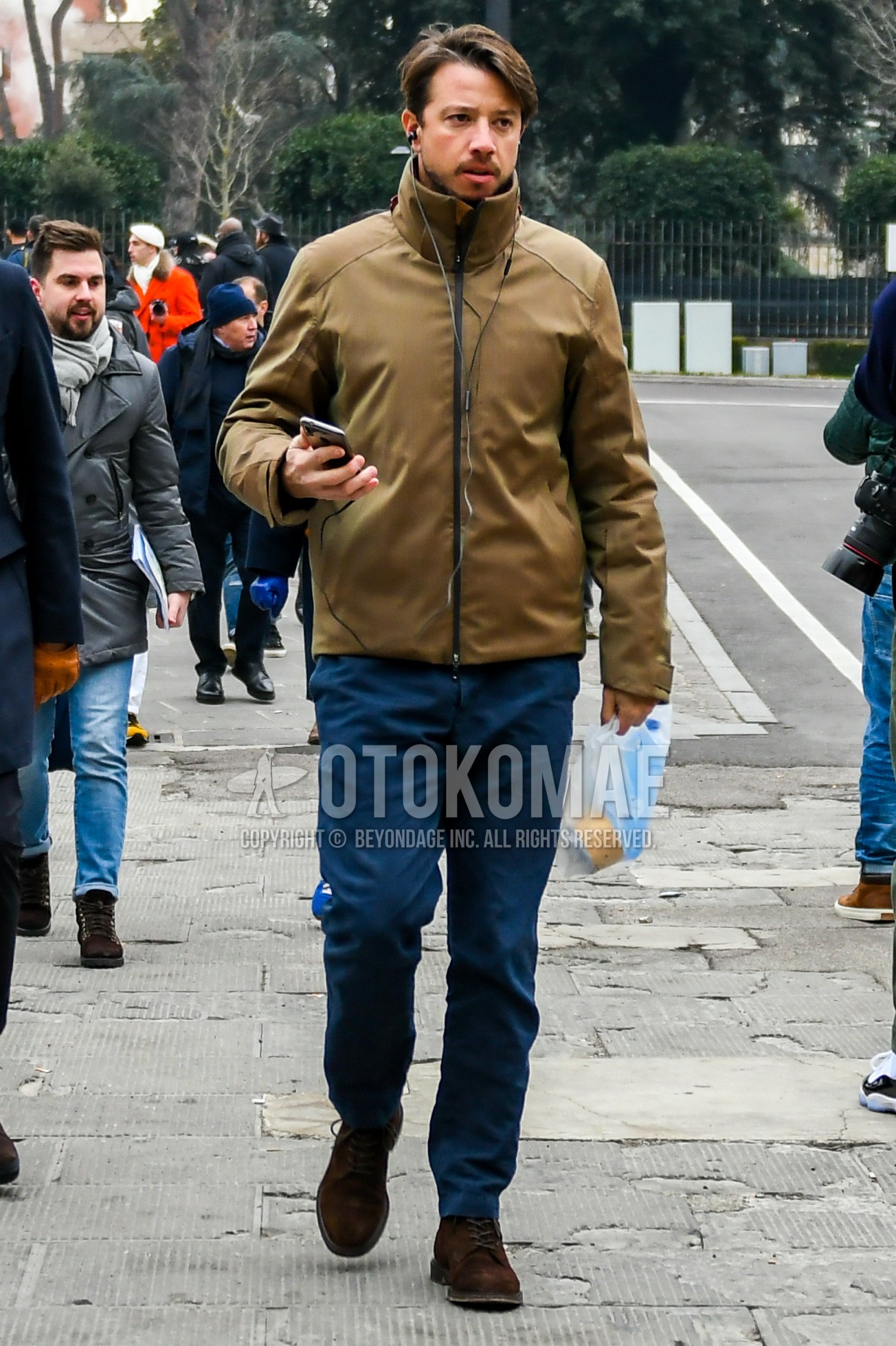 Men's autumn winter outfit with beige plain outerwear, navy plain chinos, brown  boots.