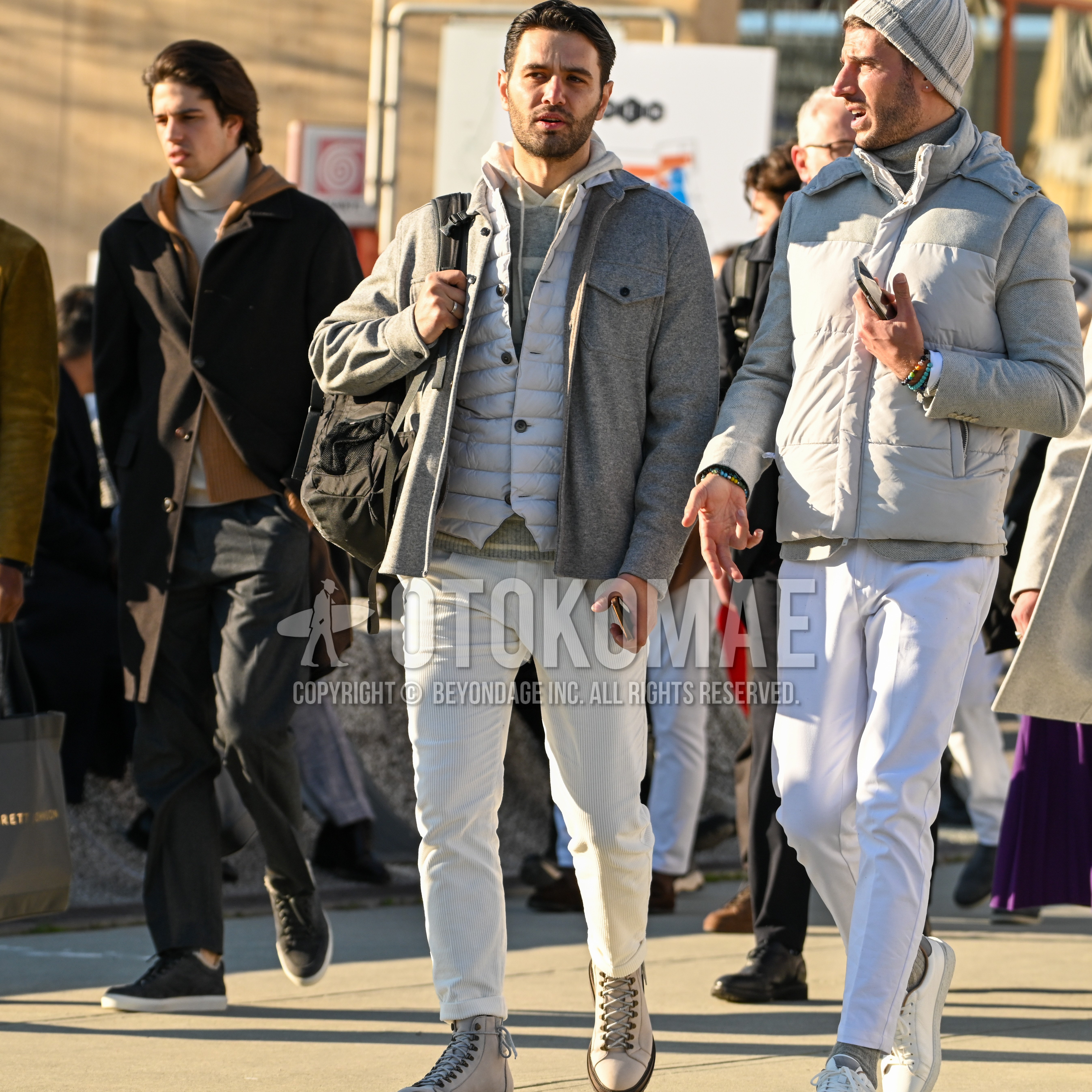 Men's autumn winter outfit with gray plain shirt jacket, gray plain inner down, gray white horizontal stripes hoodie, white plain winter pants (corduroy,velour), gray work boots, black plain backpack.