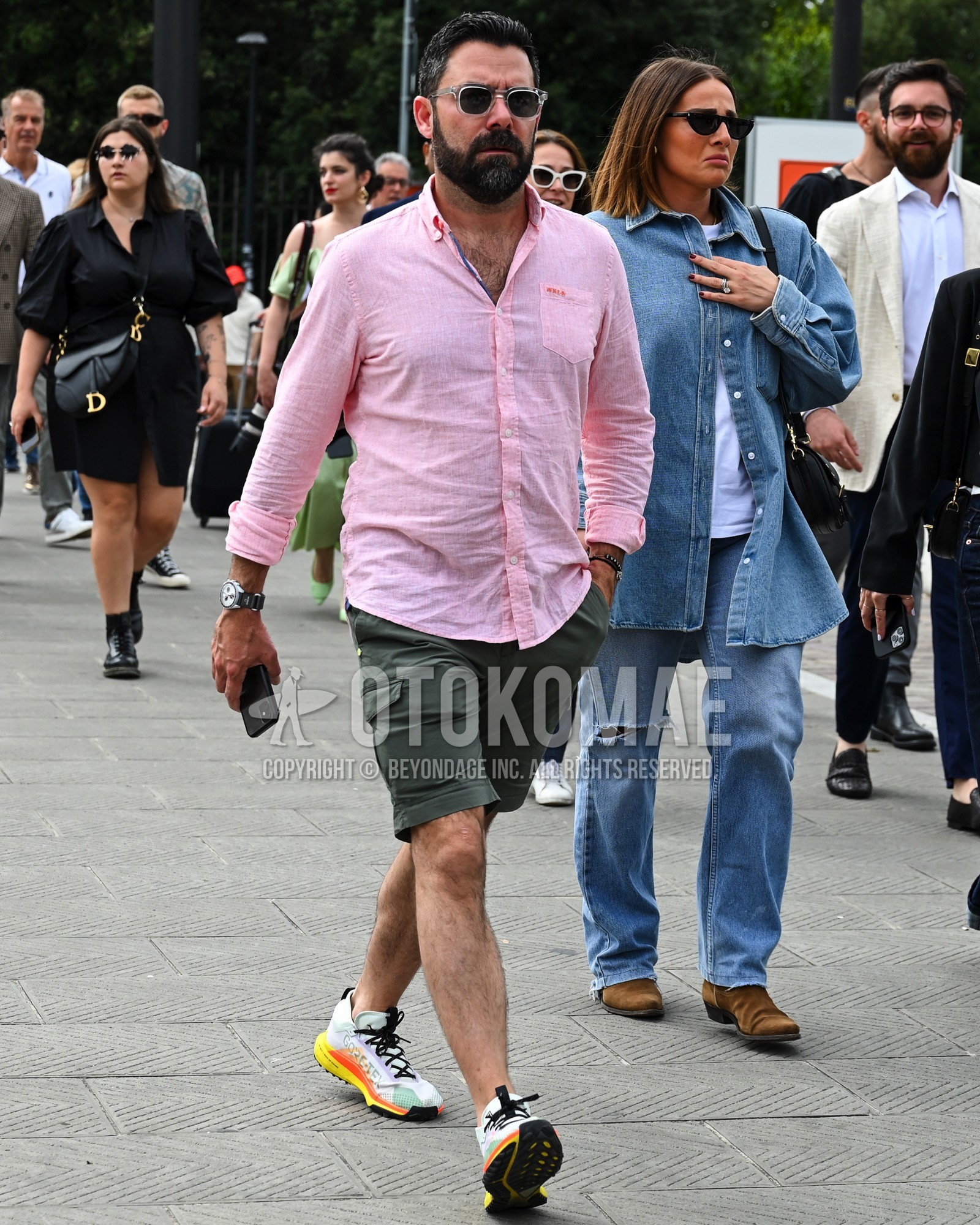 Men's spring summer outfit with pink plain shirt, green plain short pants, white low-cut sneakers.