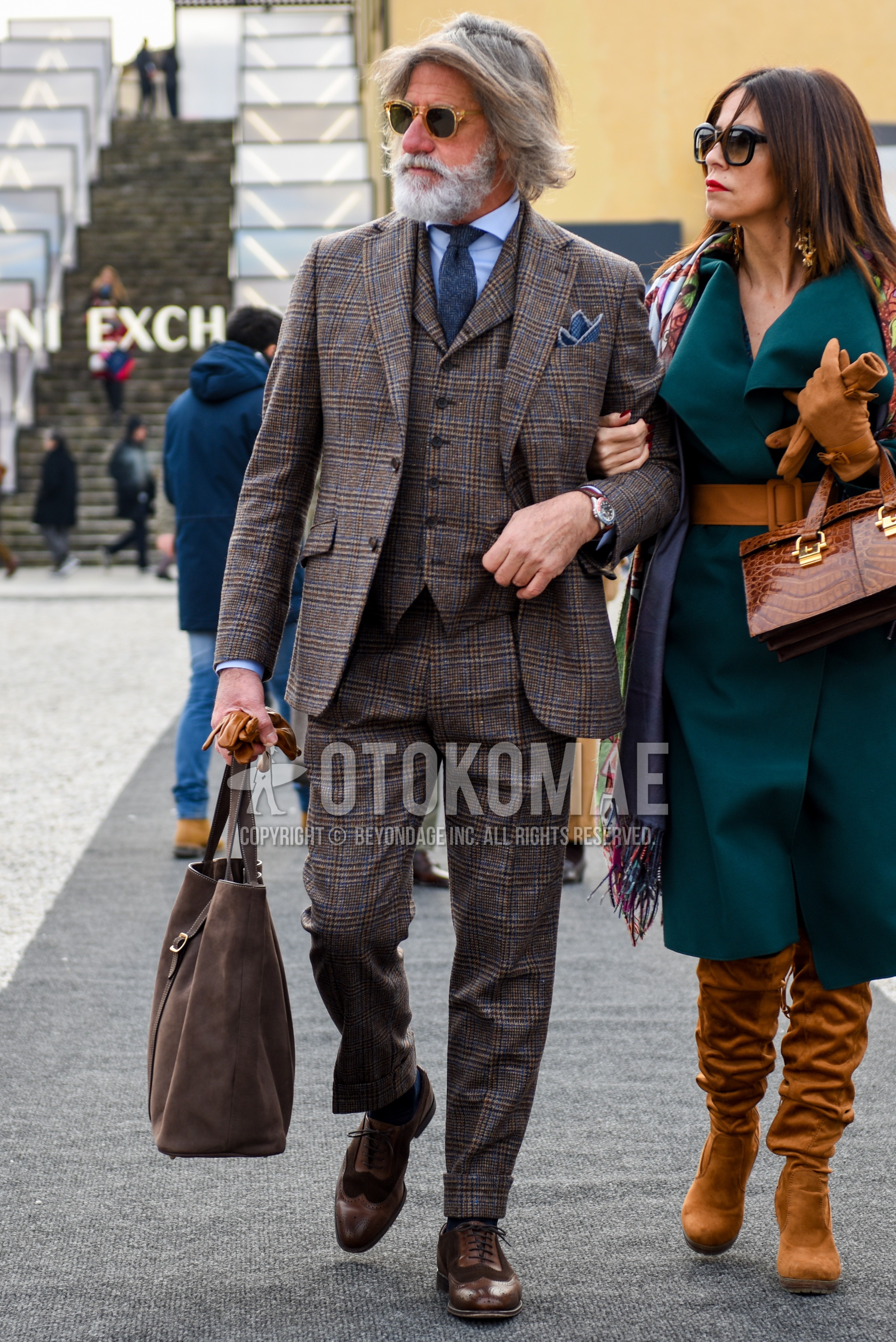 Men's spring autumn outfit with beige plain sunglasses, light blue plain shirt, brown wing-tip shoes leather shoes, brown plain briefcase/handbag, gray check three-piece suit, gray plain necktie.